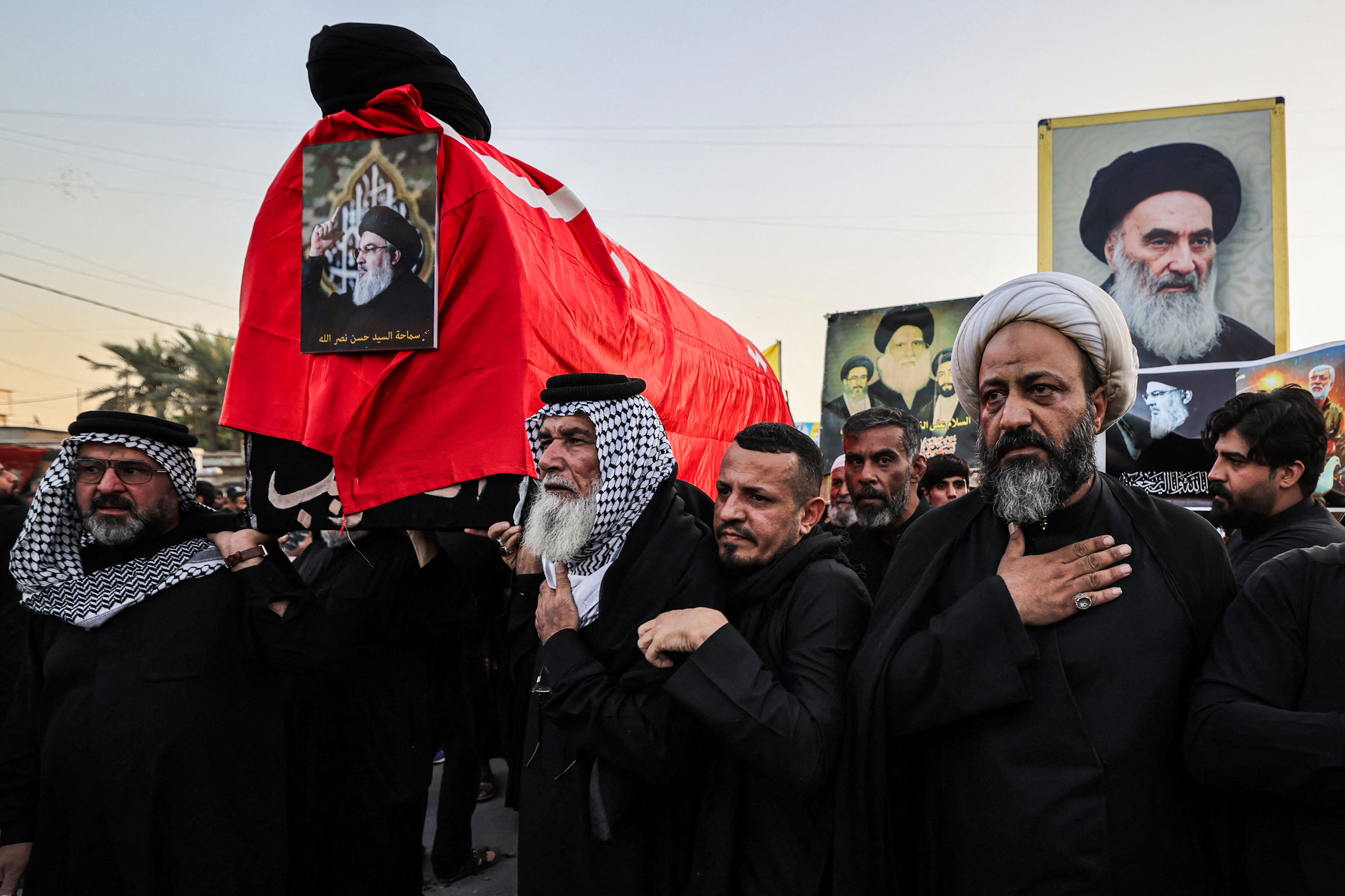Los dolientes marchan con un ataúd simbólico durante un acto conmemorativo por Hassan Nasrallah, el fallecido líder del grupo chií libanés Hezbolá, quien murió en un ataque aéreo israelí en Beirut la semana anterior. La ceremonia tuvo lugar este 29 de setiembre, en el suburbio oriental de Sadr City, en Bagdad, tras la declaración oficial de Iraq de un período de duelo nacional de tres días en honor a Nasrallah. (Foto de AHMAD AL-RUBAYE / AFP)