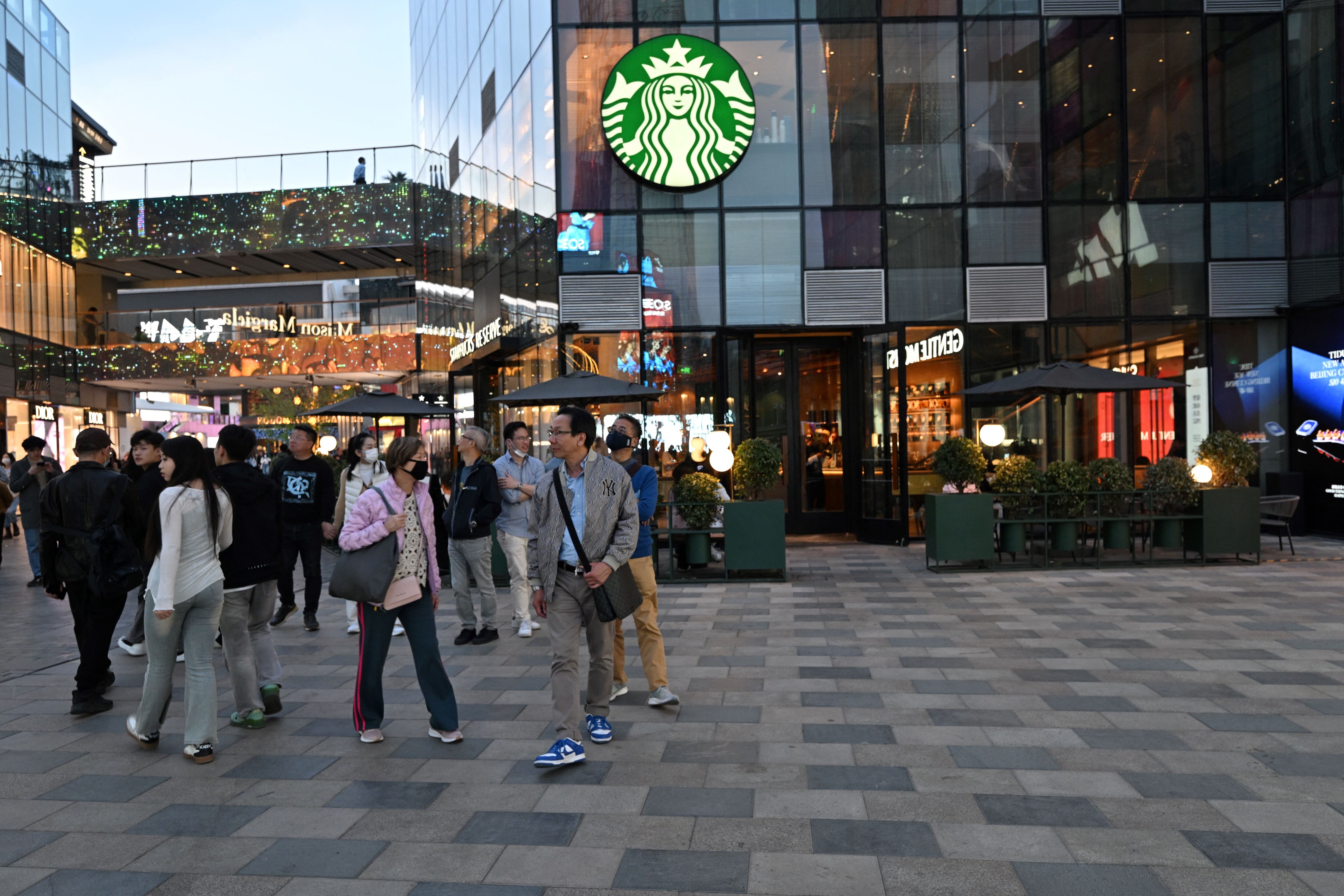 Personas frente a un Starbucks Reserve en Pekín este 9 de abril de 2025. China impondrá aranceles del 84 % a las importaciones estadounidenses, frente al 34 %, según anunció el Ministerio de Finanzas chino. Fotografía: