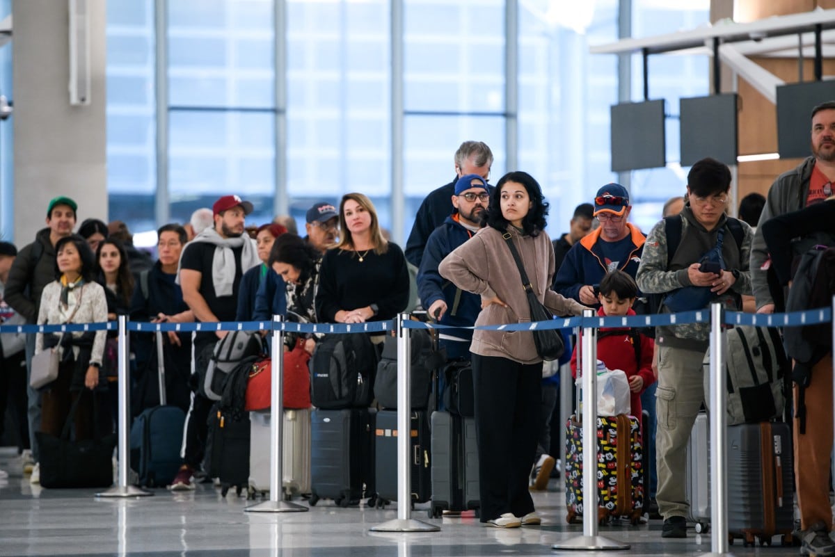 (FILES) People wait in a security checkpoint line at George Bush Intercontinental Airport in Houston, Texas, on November 4, 2025. The US government shutdown became the longest ever on November 5, 2025, topping the 35-day record set during Donald Trump's first term, as his administration warned of holiday air travel chaos and threatened Americans' benefits in a bid to force a resolution. (Photo by Mark Felix / AFP)