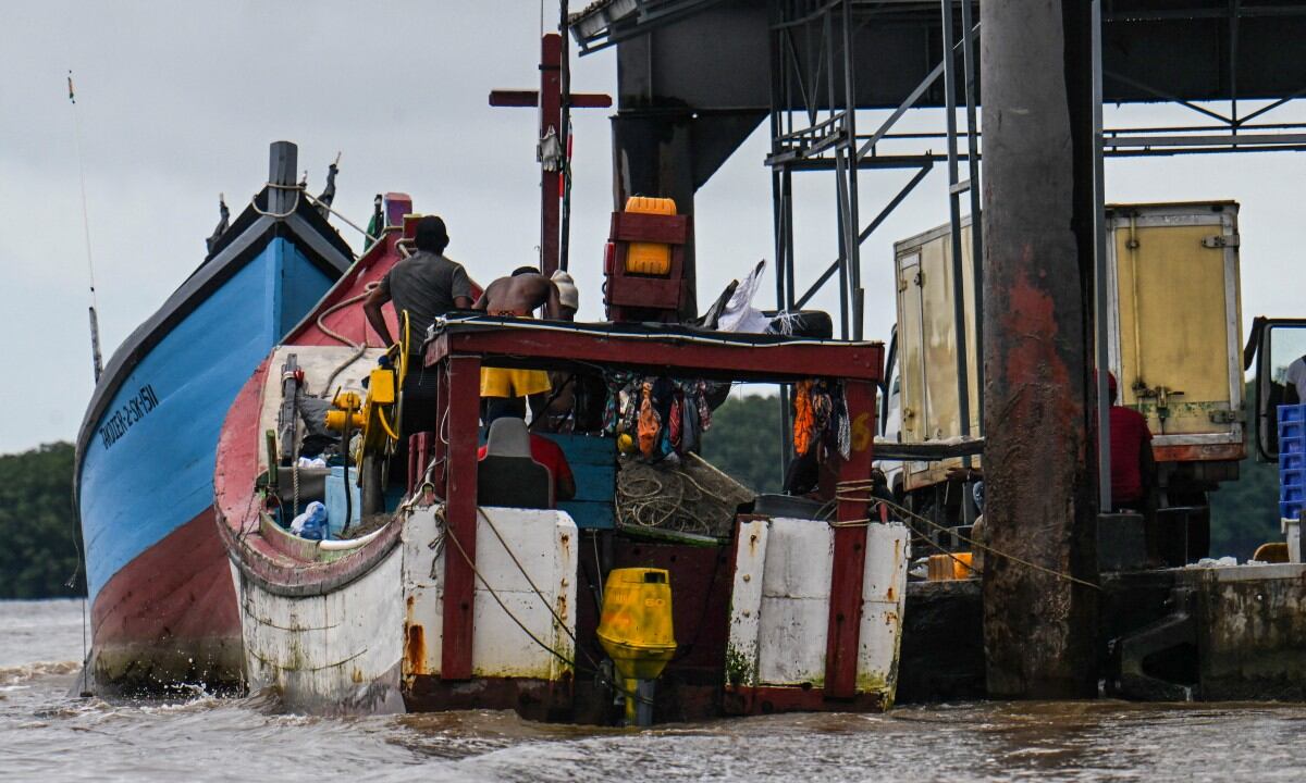 Un pescador trabaja en un barco en la isla Braamsput en Paramaribo el 24 de mayo de 2025. Surinam, el país más pequeño de América del Sur, se está preparando para una entrada de efectivo proveniente de un enorme hallazgo de petróleo en alta mar, y el presidente insiste en que la población recibirá una parte directa de la riqueza.