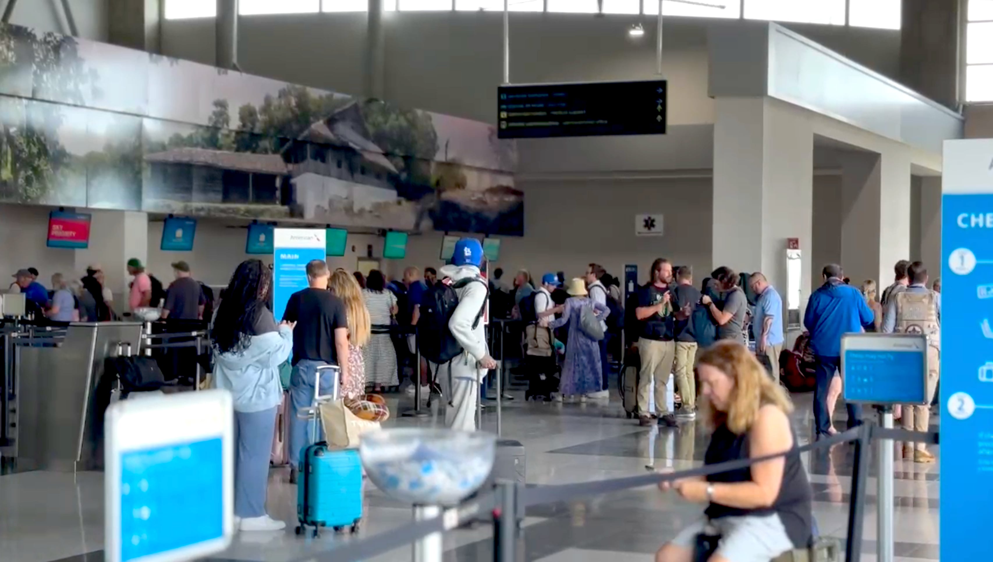 Turistas en el aeropuerto internacional Daniel Oduber en Liberia, Costa Rica, reanudación de operaciones tras dos días de cierre por daños en la pista de aterrizaje debido a lluvias.