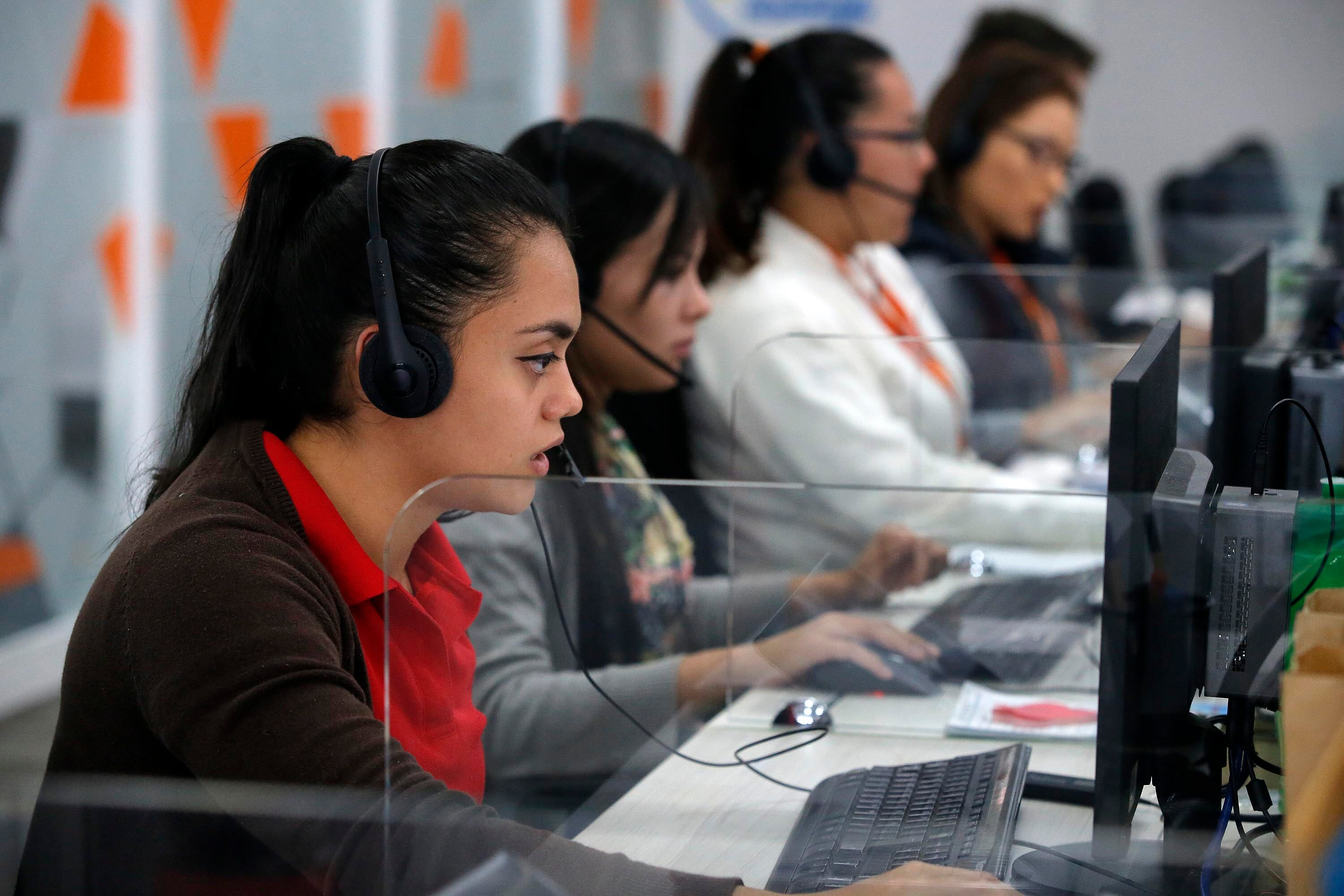 Mujeres trabajando en un centro de llamadas, ilustrando a trabajadores asalariados afectados por el ajuste al impuesto sobre la renta en Costa Rica en 2025.