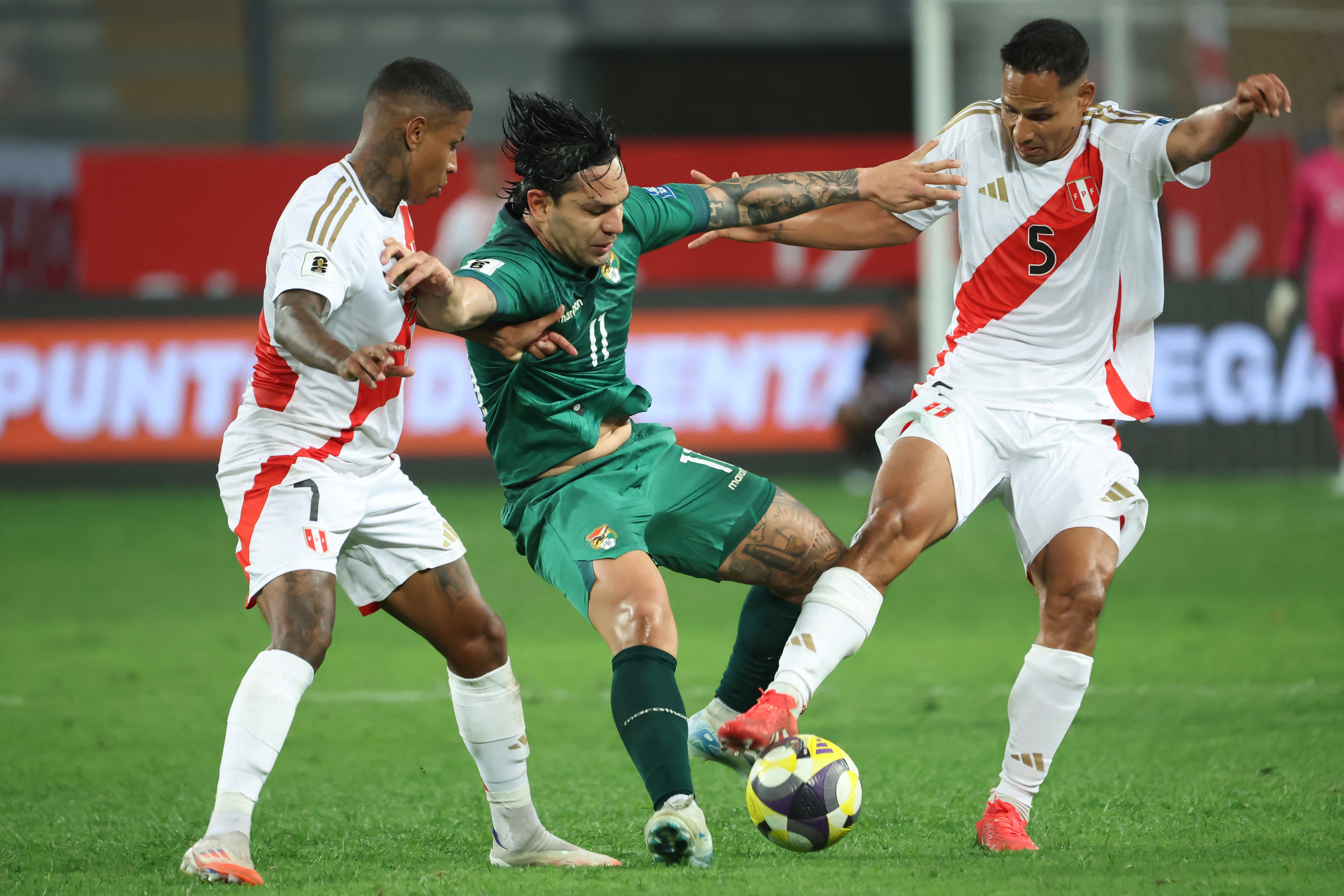 El delantero de Perú, número 07, Andy Polo, el delantero de Bolivia, número 11, Carmelo Algarañaz, y el defensor peruano, número 05, Renzo Garcés, disputan el balón durante el partido de las Eliminatorias Sudamericanas al Mundial 2026 entre Perú y Bolivia, en el Estadio Nacional de Lima, el 20 de marzo de 2025. (Foto: ALDAIR MEJÍA / AFP)