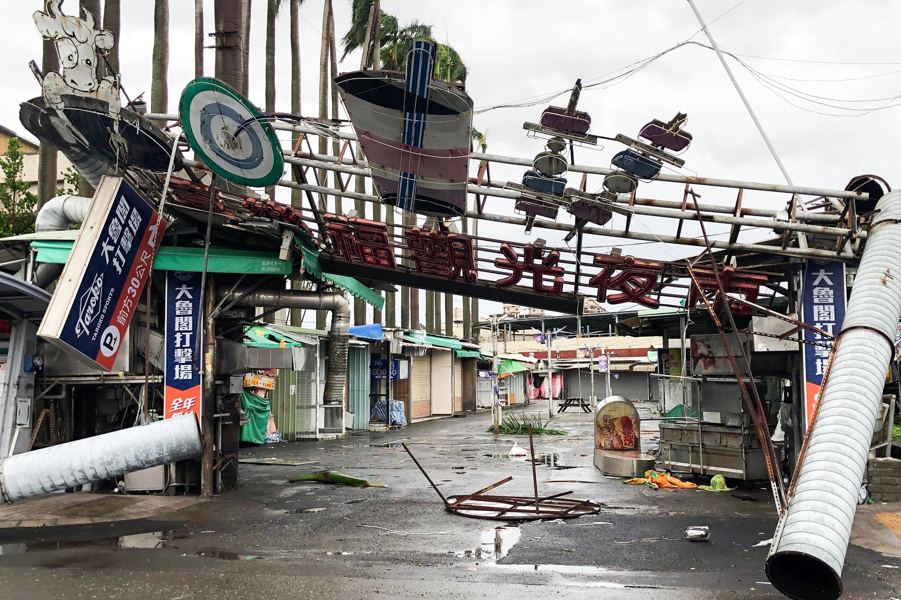 Fotografía divulgada por la Agencia Central de Noticias de Taiwán (CNA) del desplome de un letrero de un mercado nocturno tras ser derribado por el tifón Danas en Chiayi. Fotografia:
