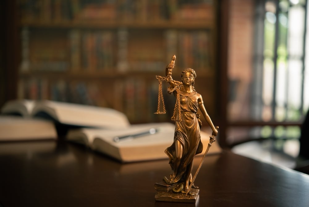 Concepto de poder judicial, jurisprudencia y justicia. Escalas de justicia, biblioteca al fondo, libros abiertos sobre mesa
