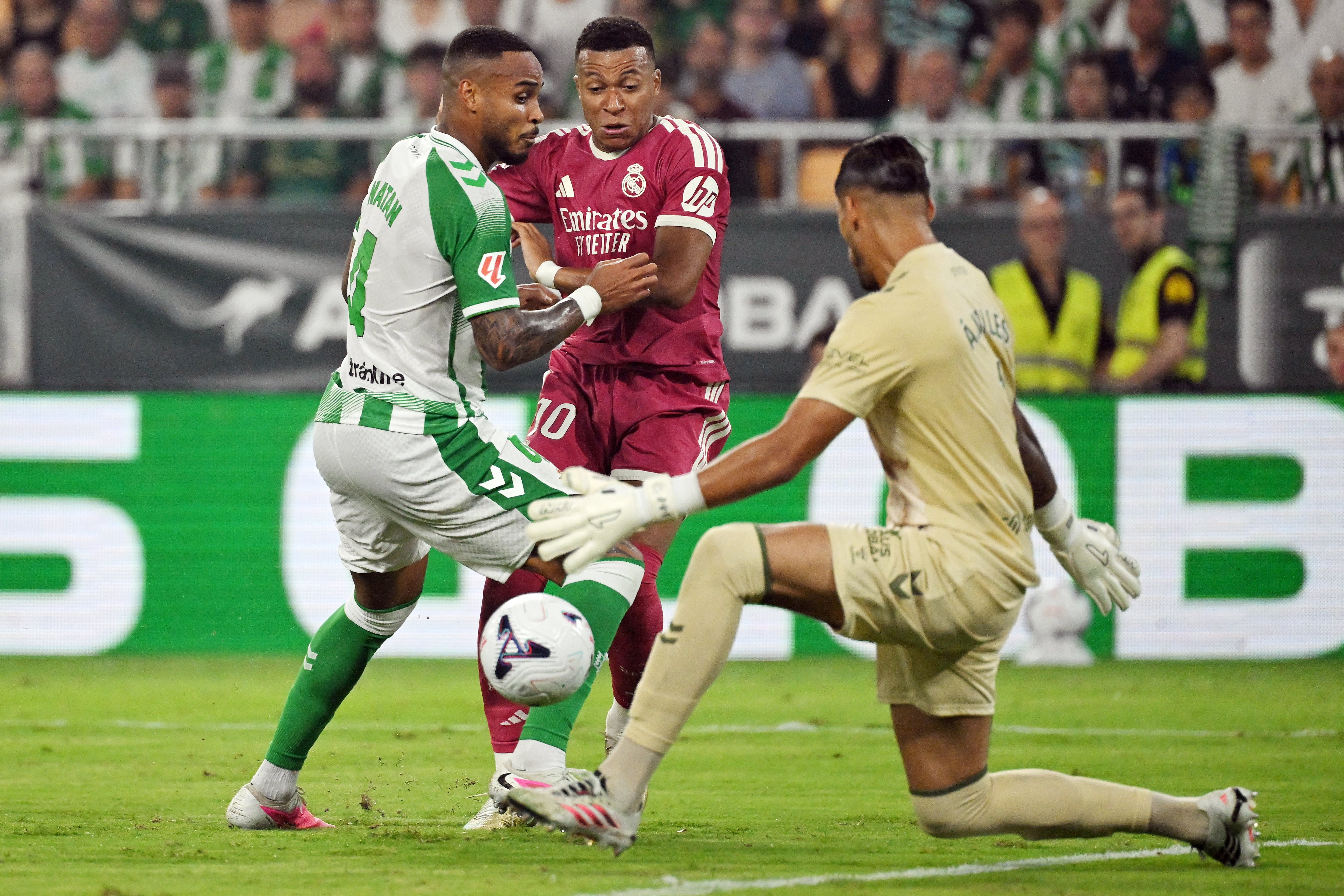 El delantero del Real Madrid Kylian Mbappé trata de superar la marca de Natan y el arquero Álvaro Valle, del Betis, durante la derrota del cuadro merengue por la Liga Española.
