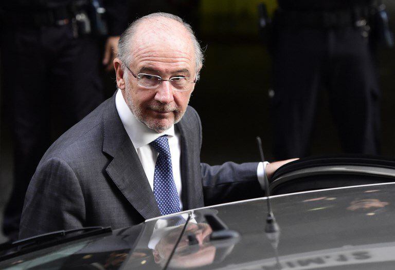 Rodrigo Rato, exdirector del Fondo Monetario Internacional (FMI) de traje oscuro y corbata gris aborda un automóvil negro.