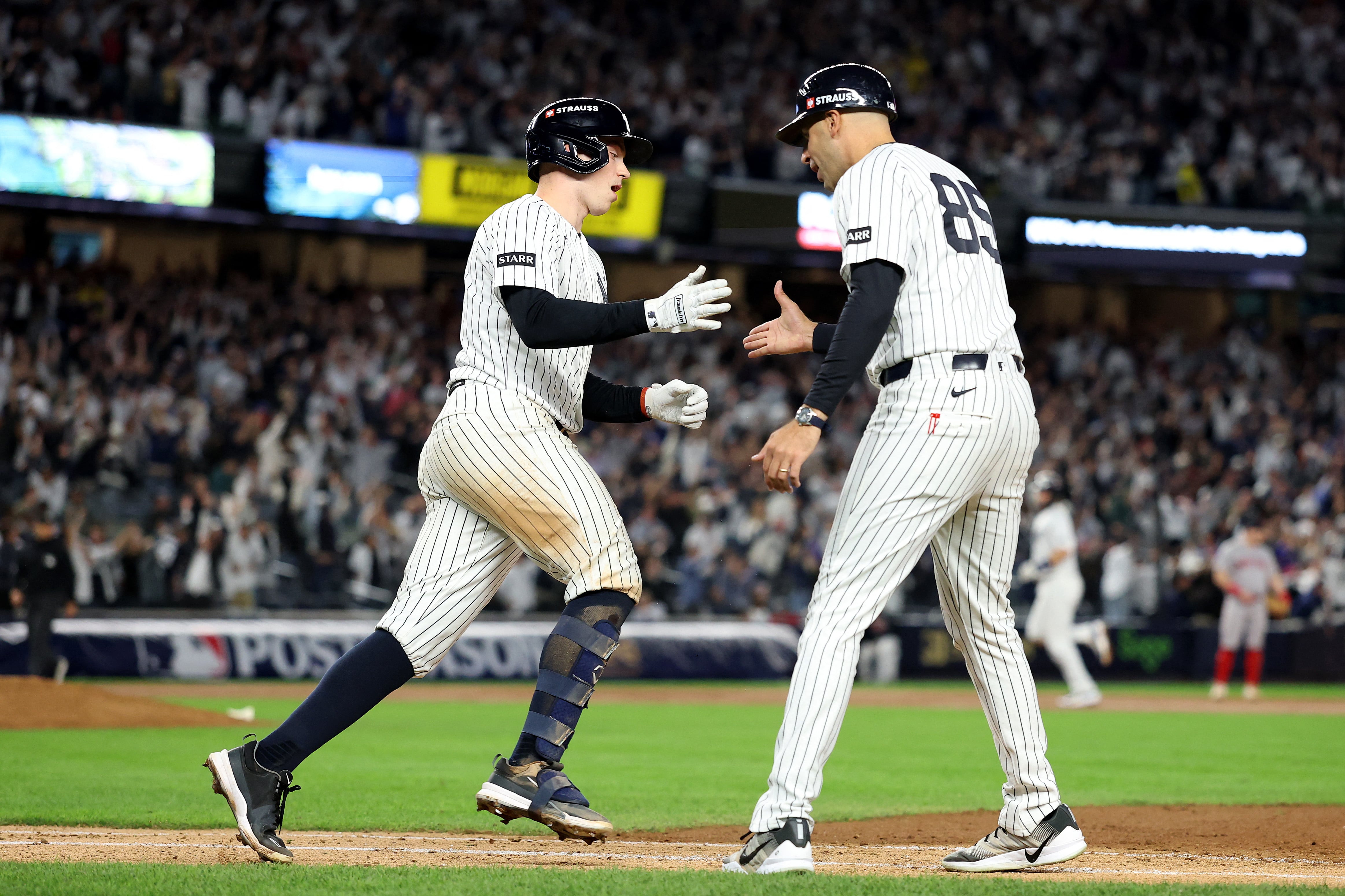 Ben Rice, de los Yanquis de Nueva York, celebra con el coach de primera Dan Fiorito tras disparar un Grand Slam ante los Medias Rojas de Boston en el inicio de la postemporada de Grandes Ligas.