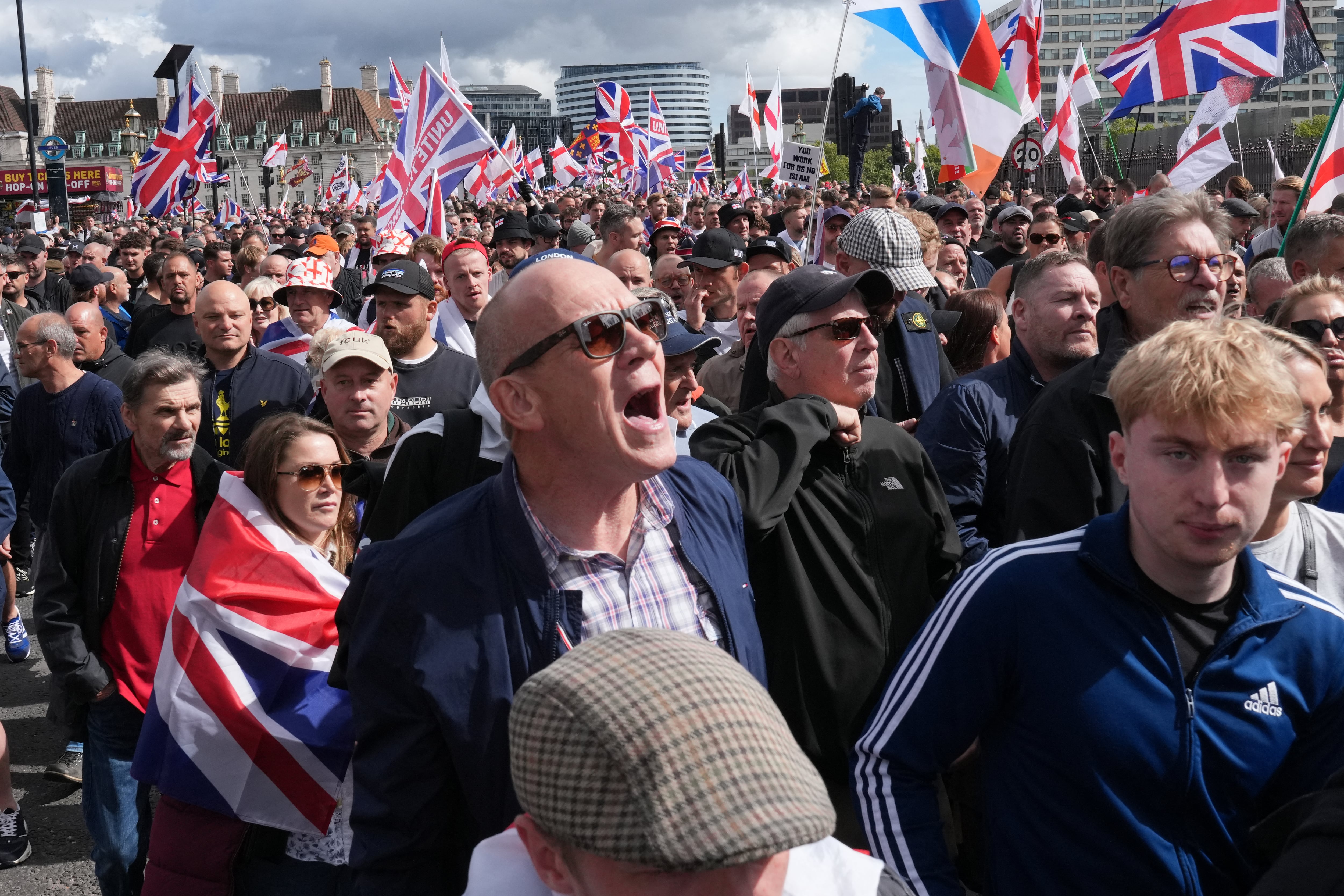 Simpatizantes del activista británico de extrema derecha Tommy Robinson, ondean banderas británicas (Union Jacks) mientras caminan por el centro de Londres