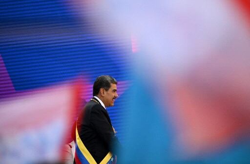 Nicolás Maduro con la cinta presidencial de Venezuela colocada de forma transversal desde el hombro izquierdo, sobre un fondo azul, rojo y blanco, representando el inicio de su tercer mandato.
