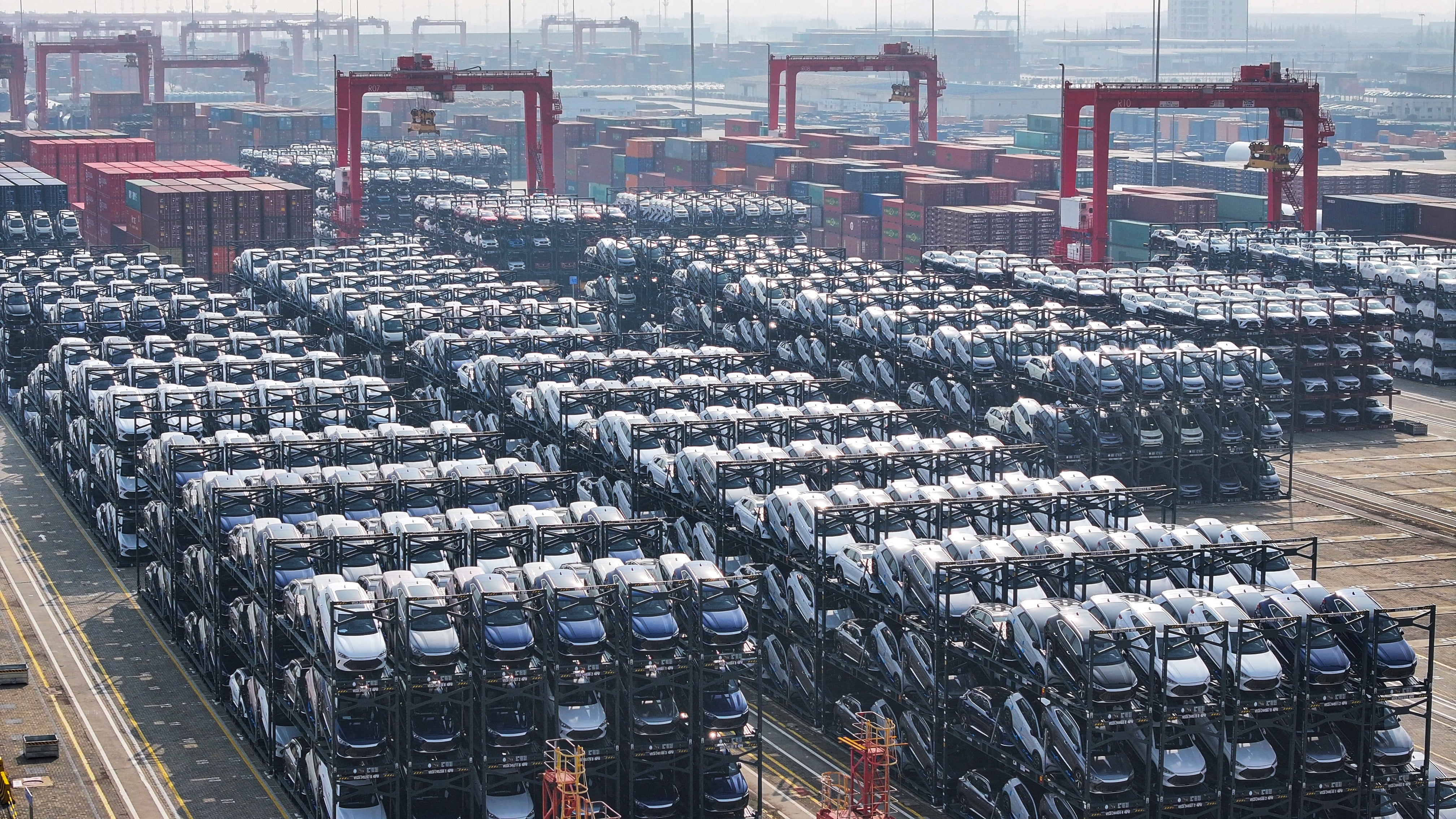 (FILES) BYD electric cars waiting to be loaded onto a ship are seen stacked at the international container terminal of Taicang Port in Suzhou, in China�s eastern Jiangsu province on February 8, 2024. Chinese electric vehicle giant BYD reported surging sales on October 30, 2024, surpassing global rival Tesla in quarterly revenue for the first time ever as its push into overseas markets advances. (Photo by AFP) / China OUT