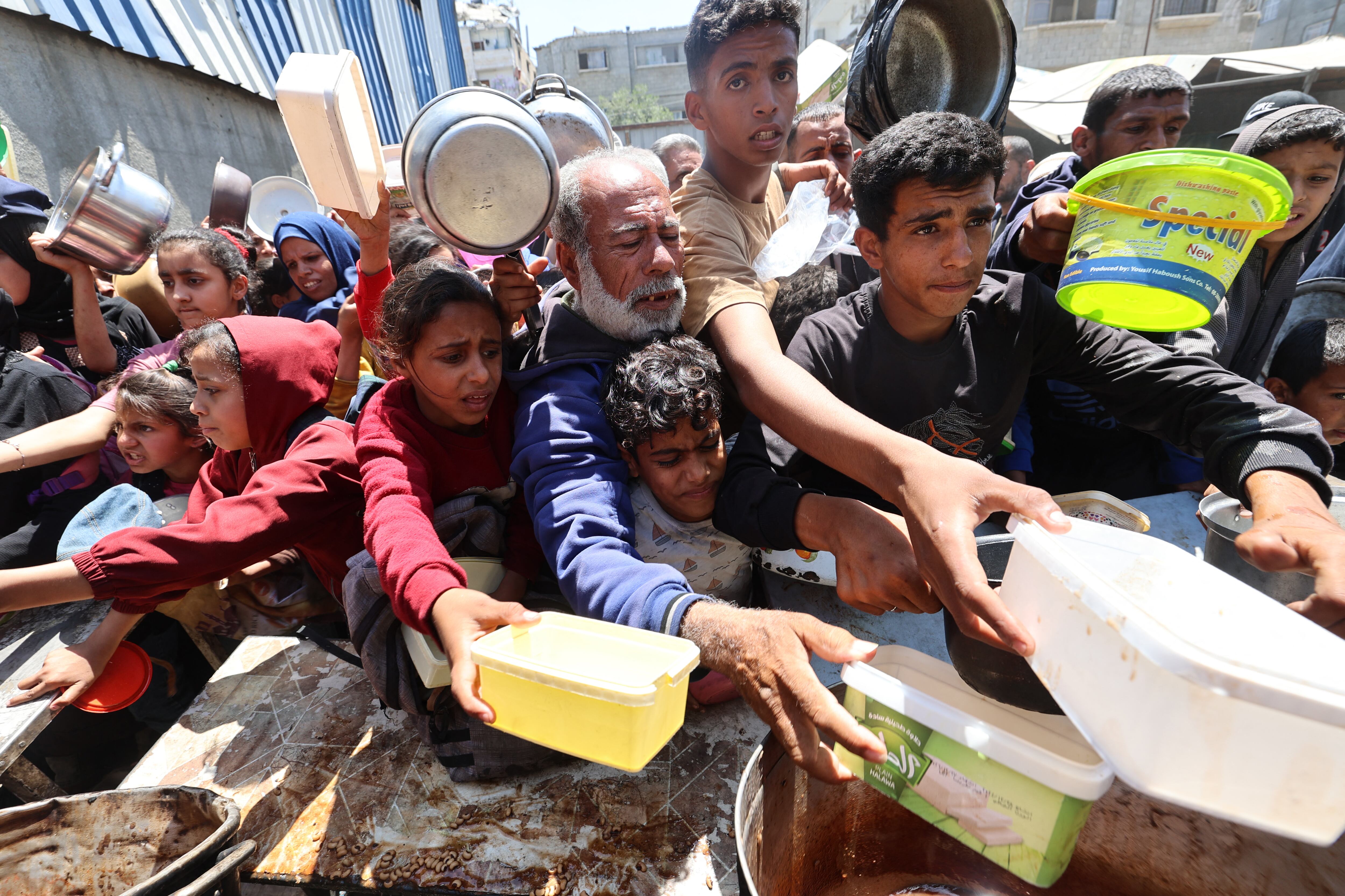 Palestinos hacen fila para recibir una comida caliente en un comedor social del campo de refugiados de Nuseirat, en el centro de la Franja de Gaza, el 4 de mayo. Fotografía: