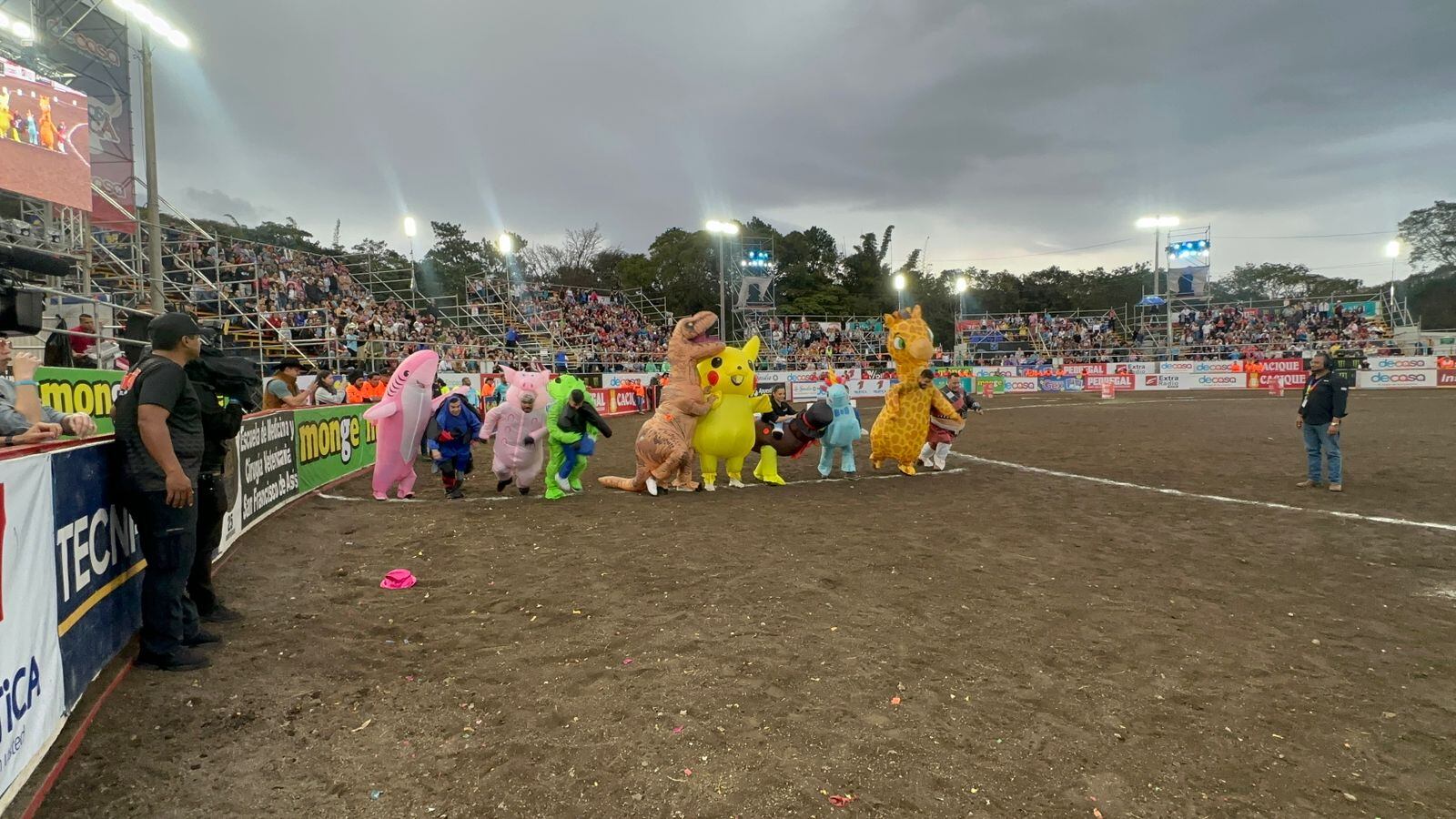 Imagen de los presentadores de Toros de Teletica vestidos con botargas. Se ven un tiburón rosado, un ninja, un extraterrestre verde, un dinosaurio, un Pikachu, un chompipe, un unicornio, una jirafa y un pirata.