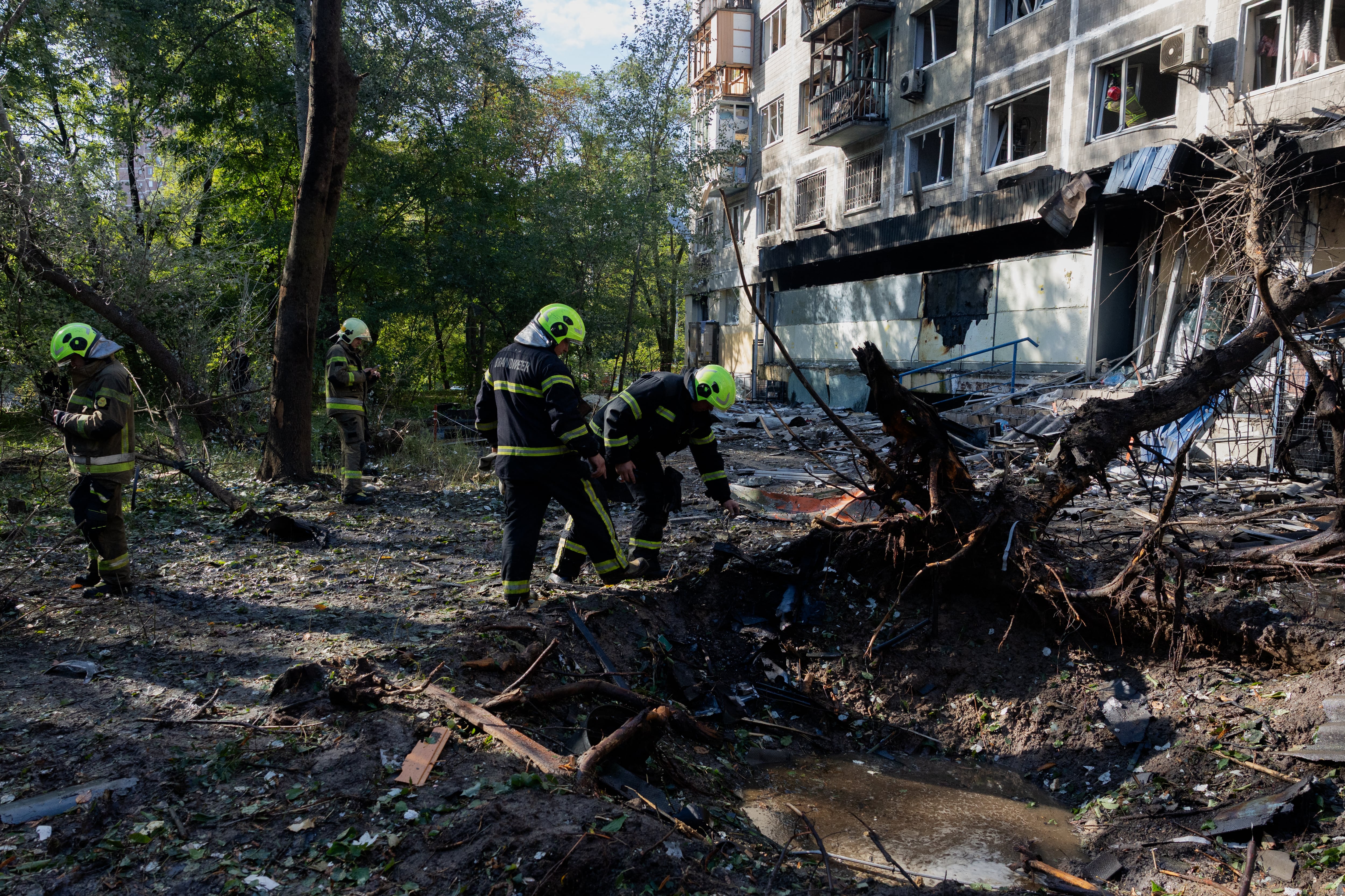 Trabajadores de rescate atienden daños en una zona residencial de Kiev, Ucrania, afectada por un bombardeo ruso que dejó siete muertos el 25 de setiembre, incluido un niño de 14 años.