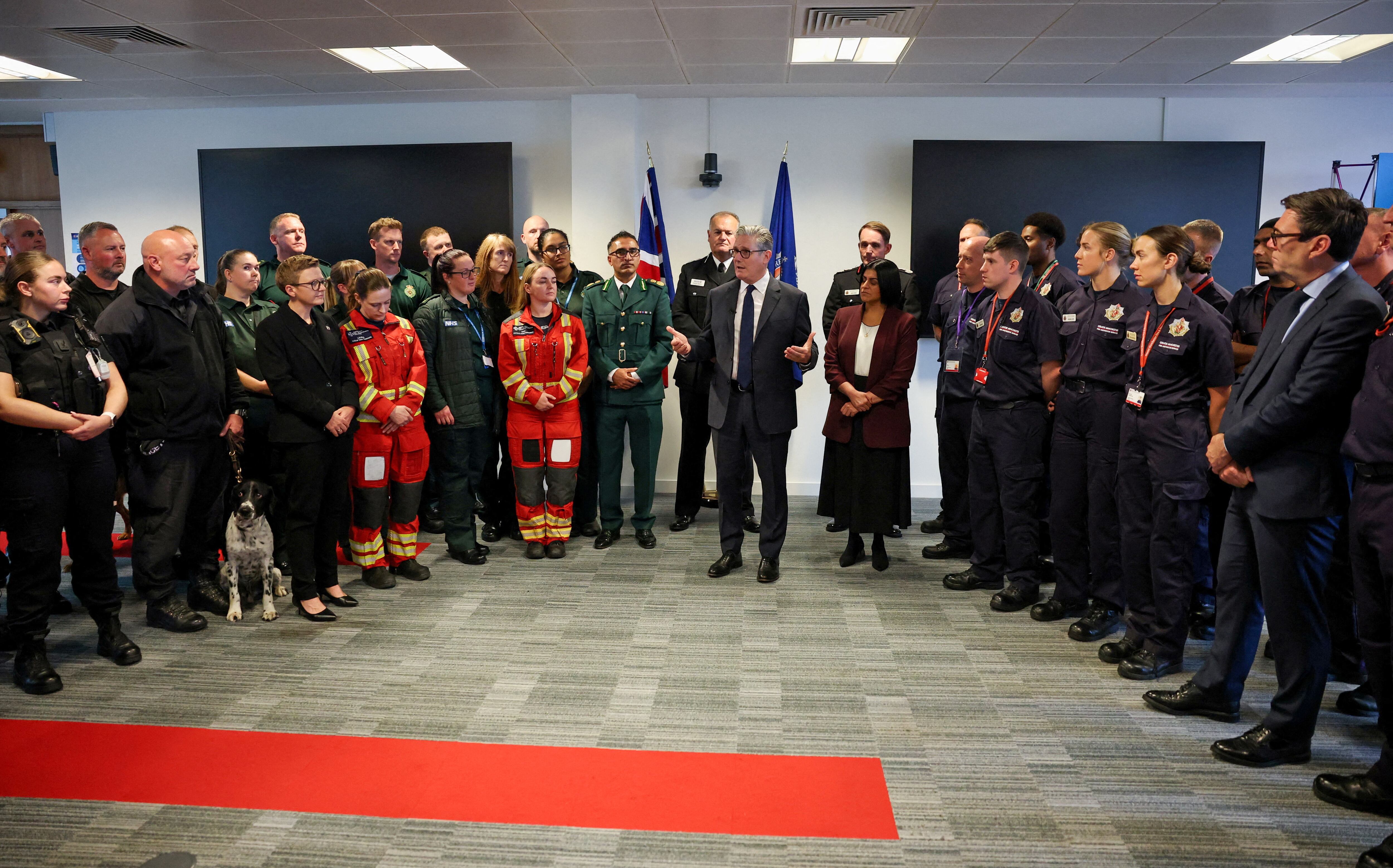El primer ministro británico, Keir Starmer (centro), y la ministra del Interior, Shabana Mahmood (centro, derecha), conversan con miembros de los Servicios de Emergencia durante una visita a la sede de la Policía del Gran Manchester el 3 de octubre de 2025, tras el atentado ocurrido ayer en la sinagoga de la Congregación Hebrea de Heaton Park.
