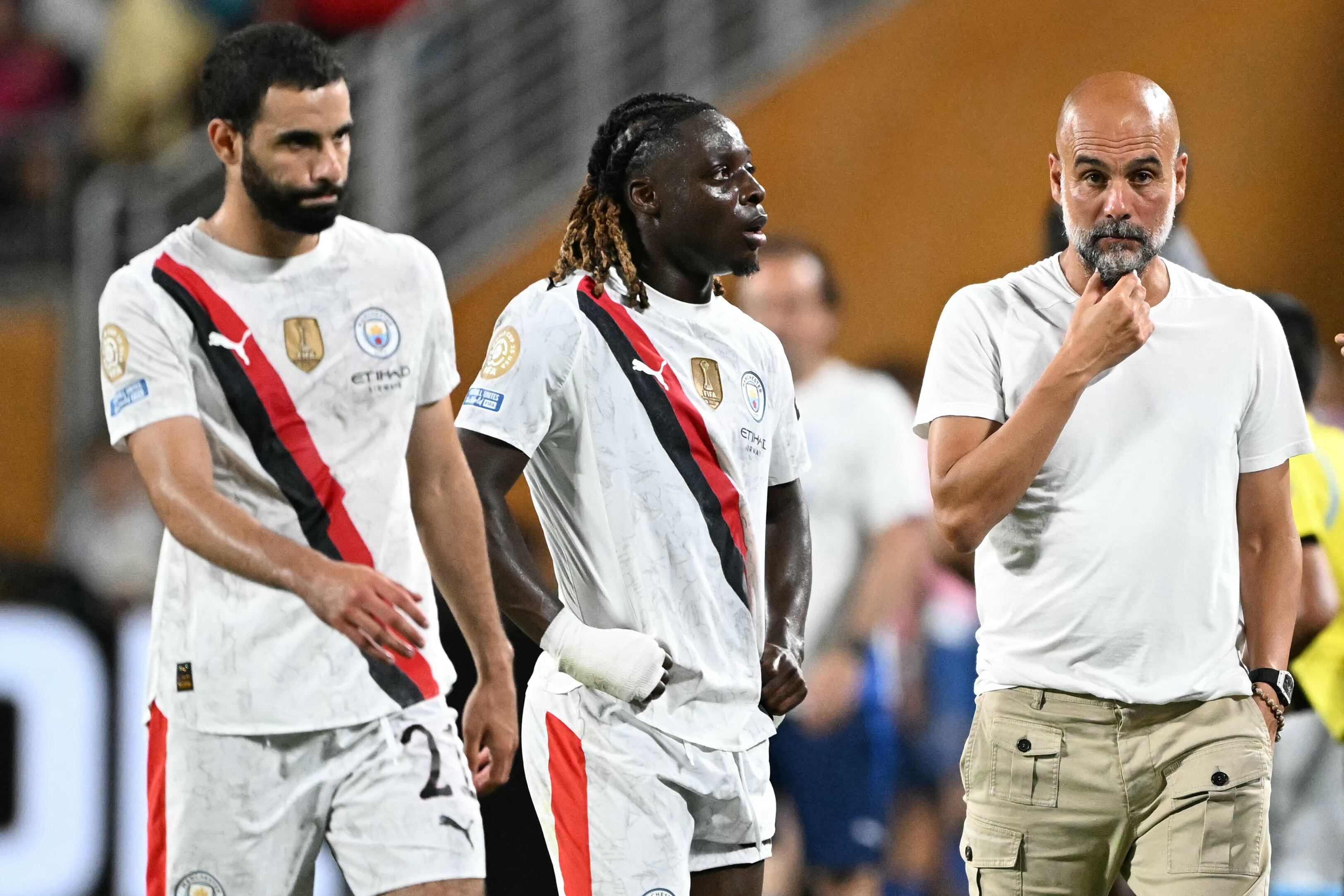 El entrenador español del Manchester City, Pep Guardiola, hace un gesto junto al defensa argelino del Manchester City, Rayan Ait-Nouri, y al centrocampista belga del Manchester City, Jeremy Doku