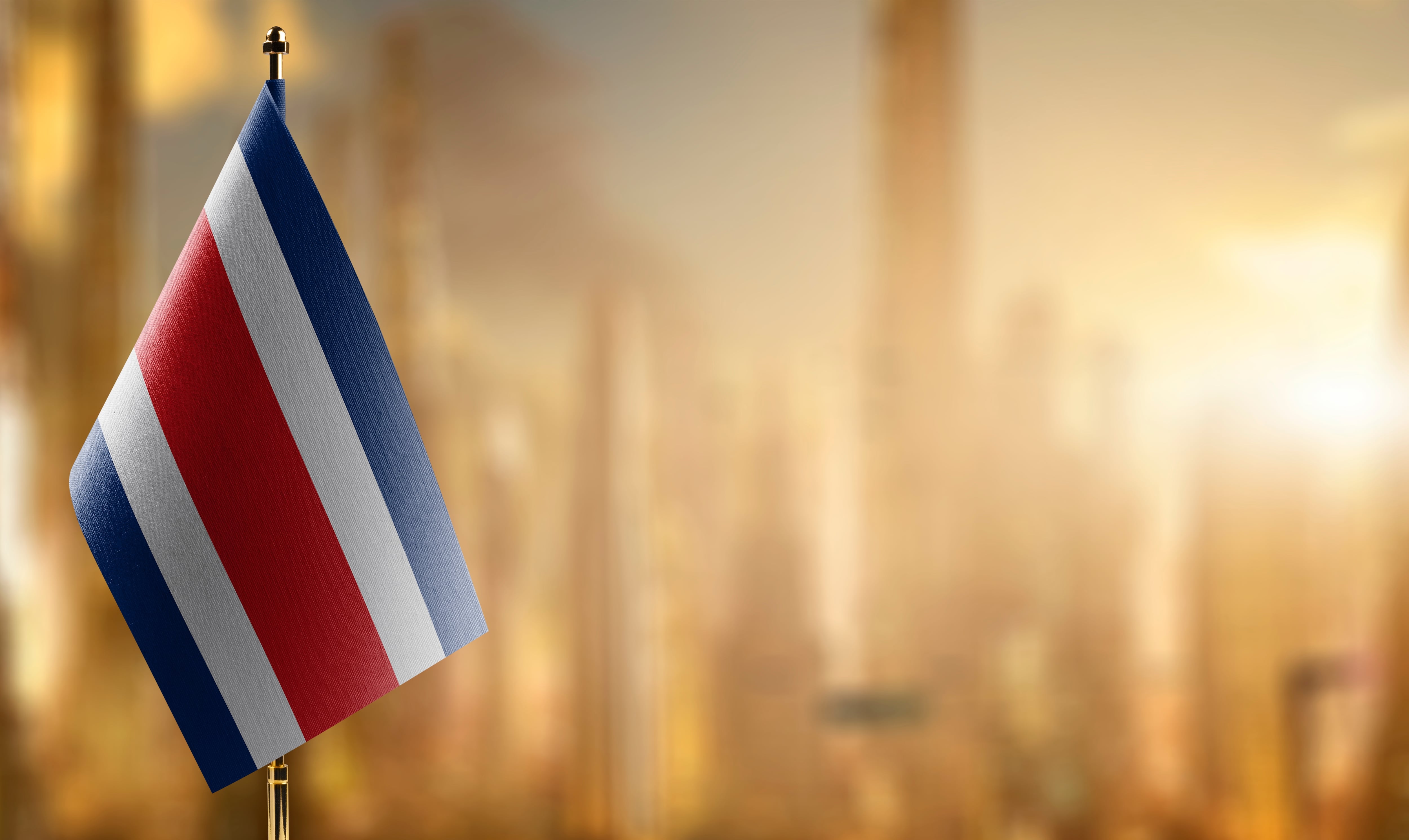 Bandera de Costa Rica contra fondo neutro de edificios