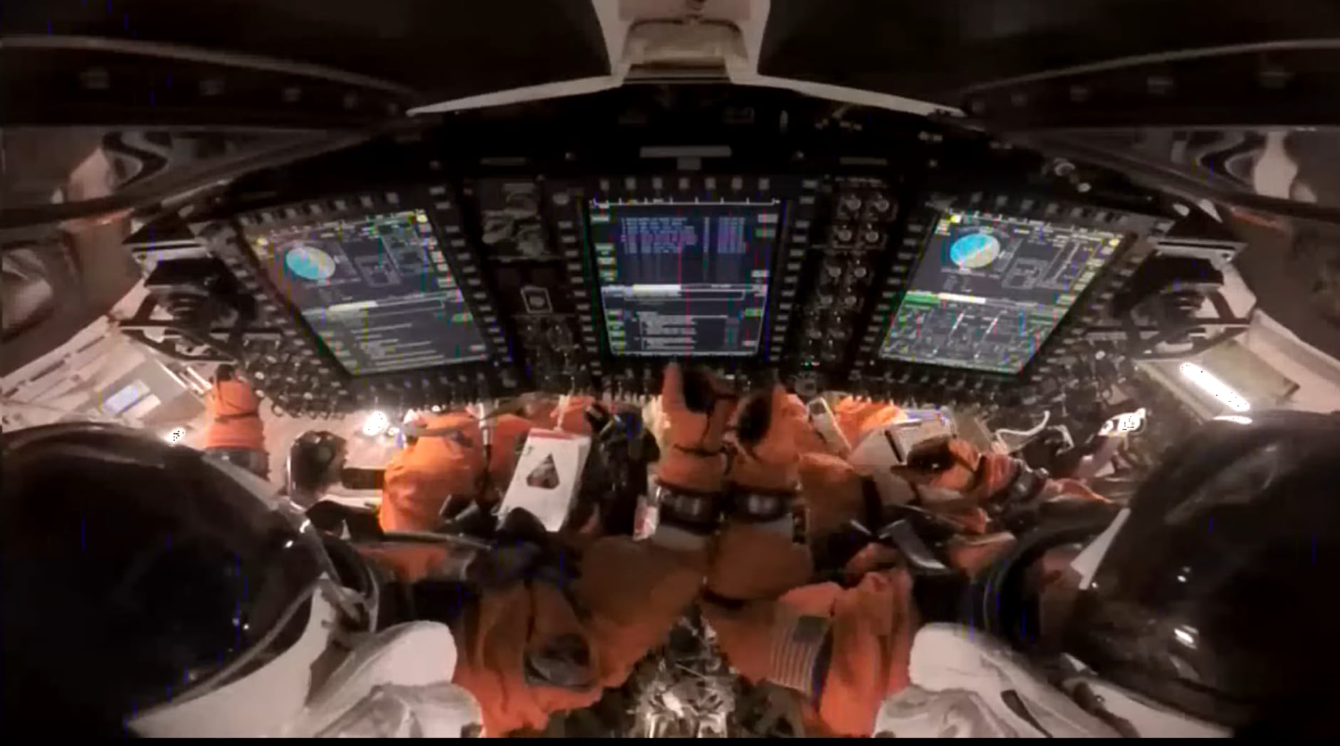 El astronauta Reid le choca al puño al piloto Victor en la nave Orion.