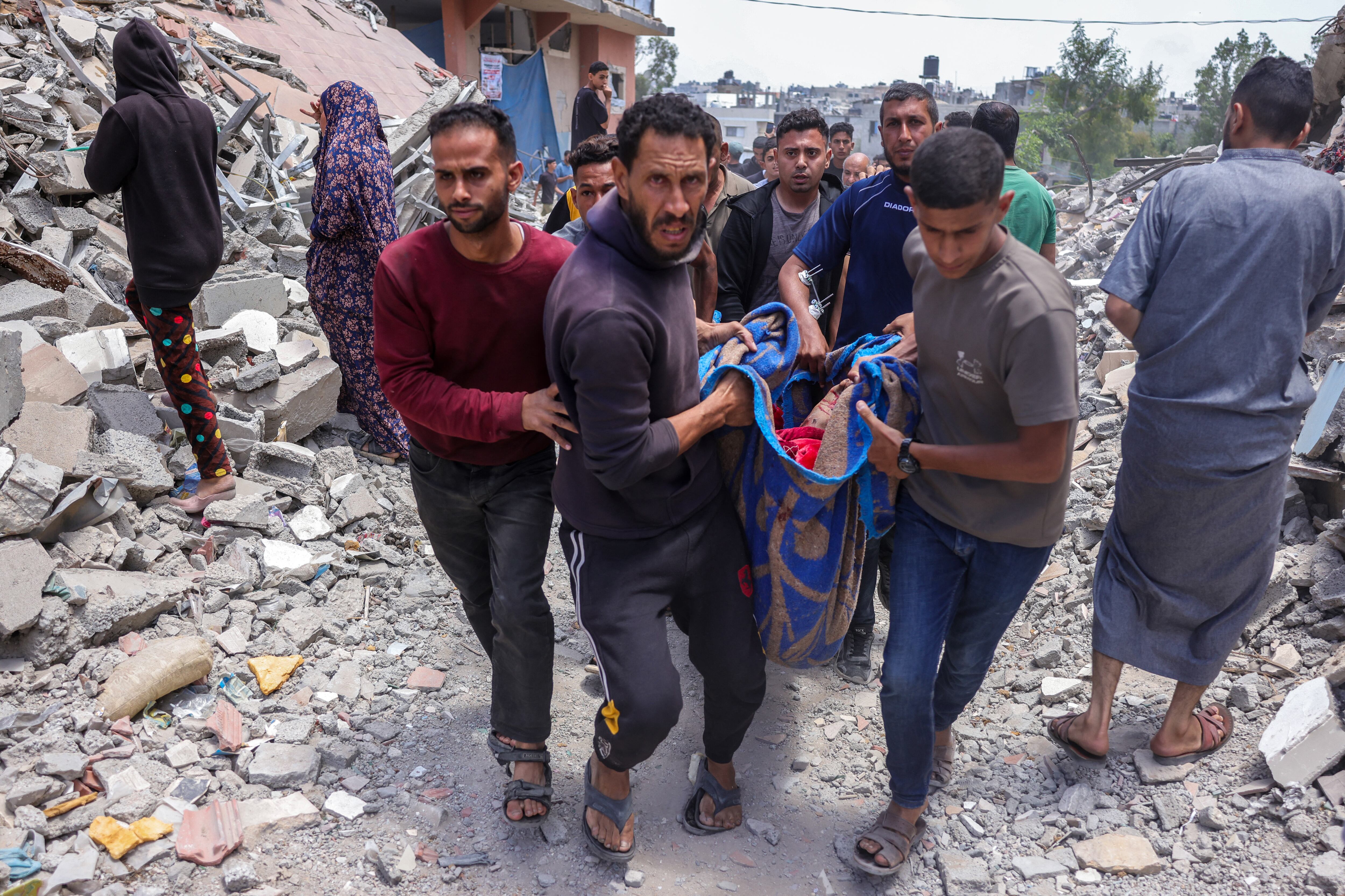 Palestinos con el cuerpo de un hombre muerto en un ataque israelí en el barrio de Saftawi, al oeste de Jabalia, en el norte de la Franja de Gaza, este martes. Fotografía: