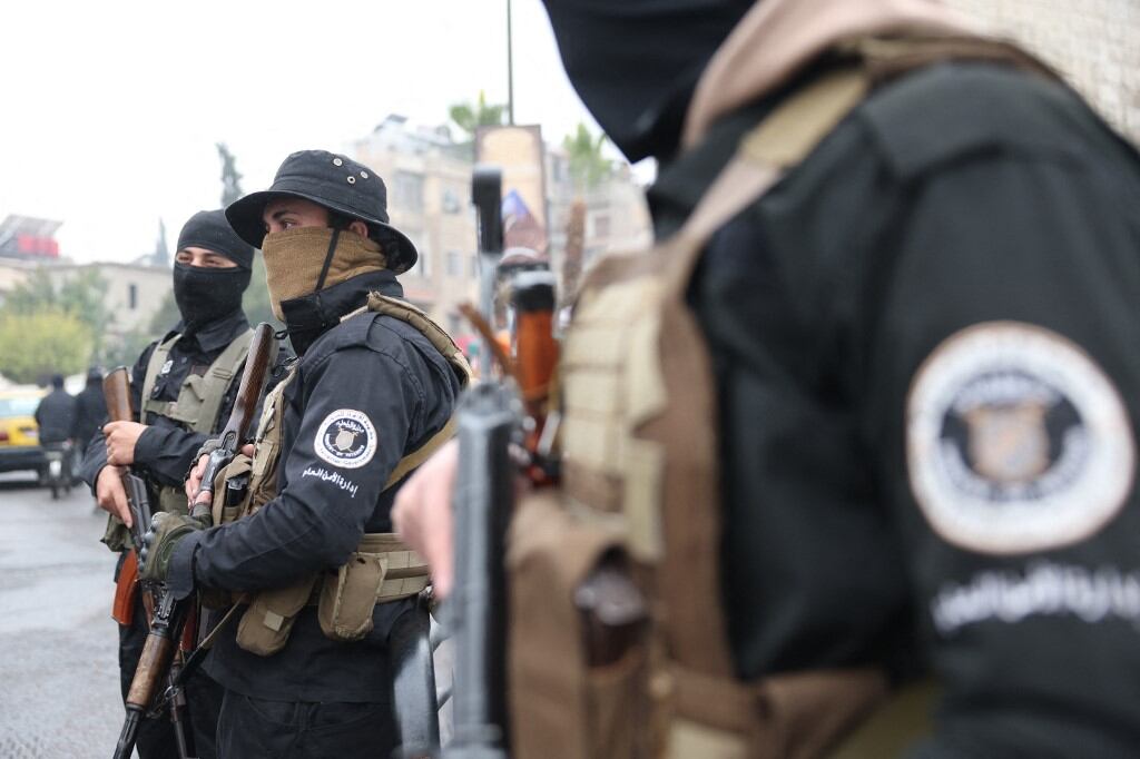 Syrian security forces, under the guidance of the transitional government, stands guard in a street in the capital Damascus on December 24, 2024. Syria's new leaders announced that they had reached an agreement with the country's rebel groups on their dissolution and integration under the defence ministry. (Photo by OMAR HAJ KADOUR / AFP)