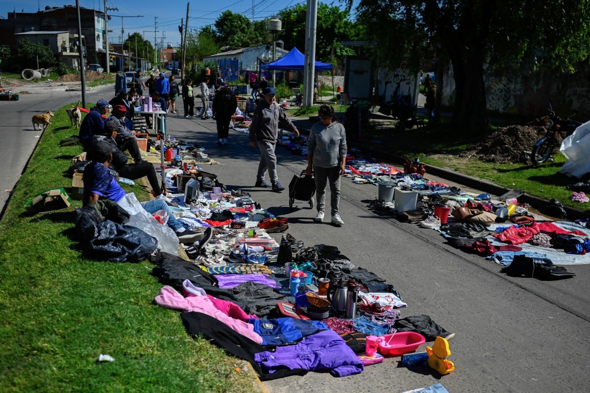Personas caminan por un mercado callejero en Villa Fiorito, en las afueras de Buenos Aires, el 19 de octubre de 2025. Los atrasos en los pagos de los hogares argentinos se triplicaron en un año y alcanzaron en 2026 su nivel más alto en dos décadas, durante el gobierno de Javier Milei. El aumento del costo de vida y los ingresos estancados figuran entre las principales causas.