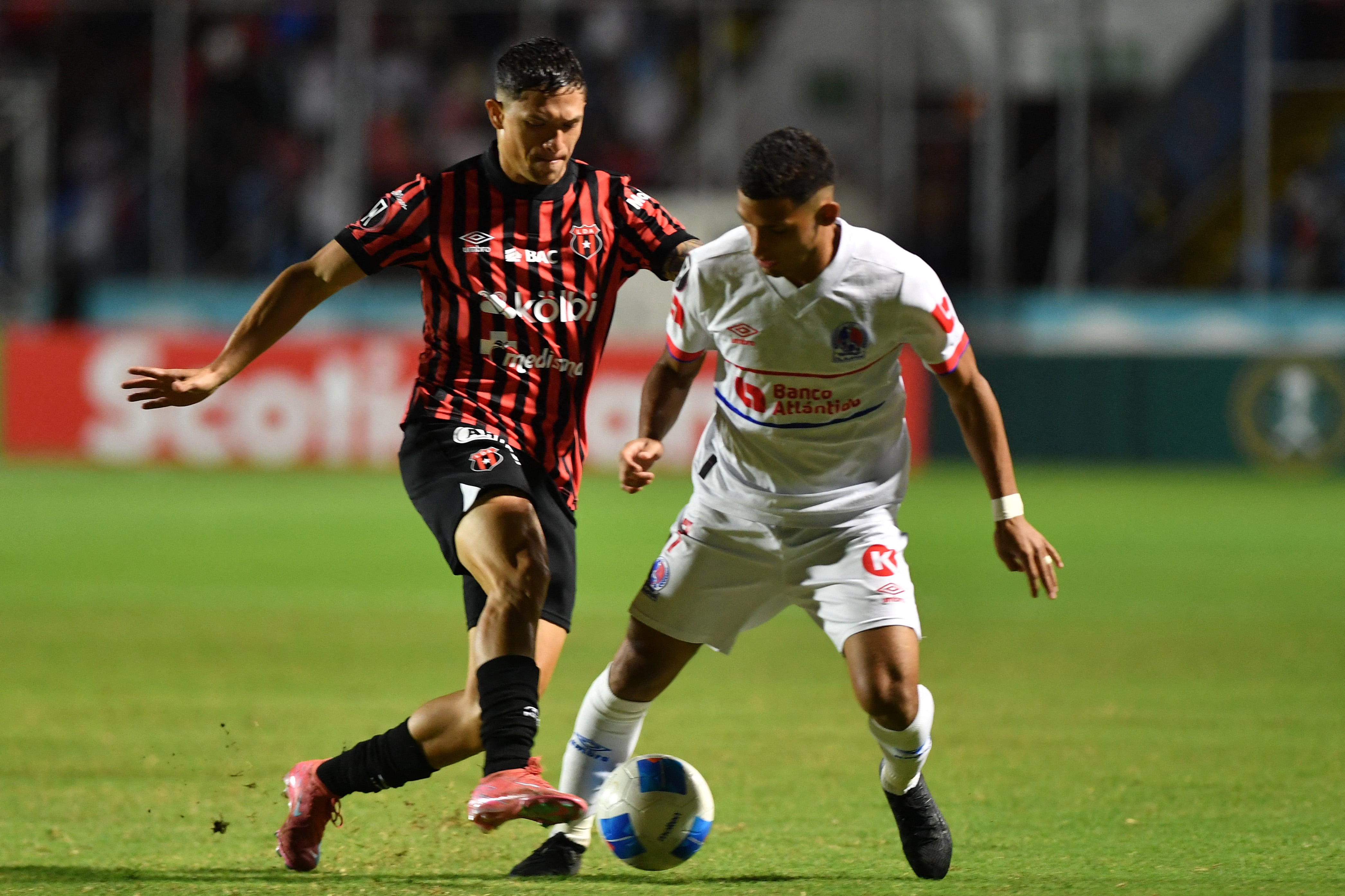 Alajuelense's forward #07 Anthony Hernandez and Olimpia's midfielder #07 Jose Pinto fight for the ball during the second leg of the CONCACAF Central American Cup semifinal football match between Honduras's Olimpia and Costa Rica's Alajuelense at the National Stadium Jose de la Paz Herrera in Tegucigalpa on October 30, 2025. (Photo by Orlando SIERRA / AFP)