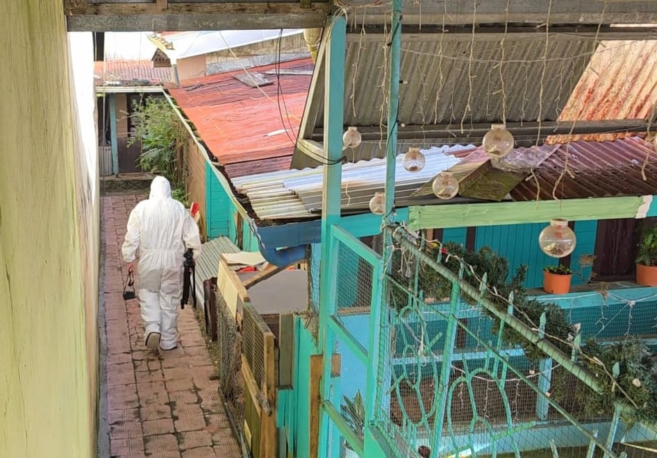 Un agente forense del OIJ ingresa por un corredor hacia la escena del crimen en Barrio Lourdes de Ciudad Quesada, San Carlos, donde una mujer fue asesinada y el caso se investiga como un presunto femicidio. El hecho ocurrió en un domicilio localizado en casas localizadas en una alameda.