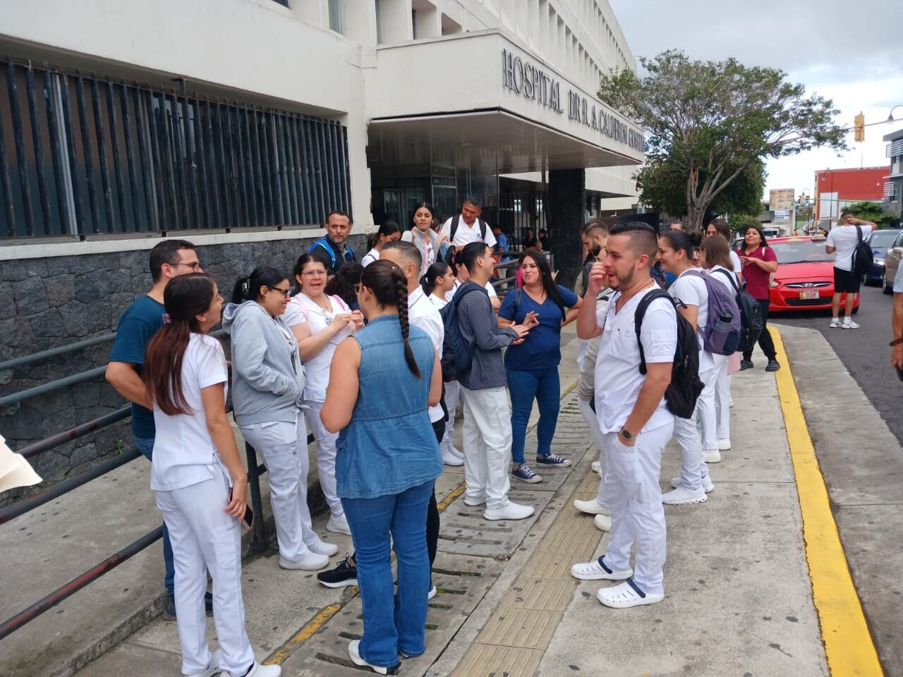Un grupo de trabajadores de la salud por fuera de un hospital. Están en paro.