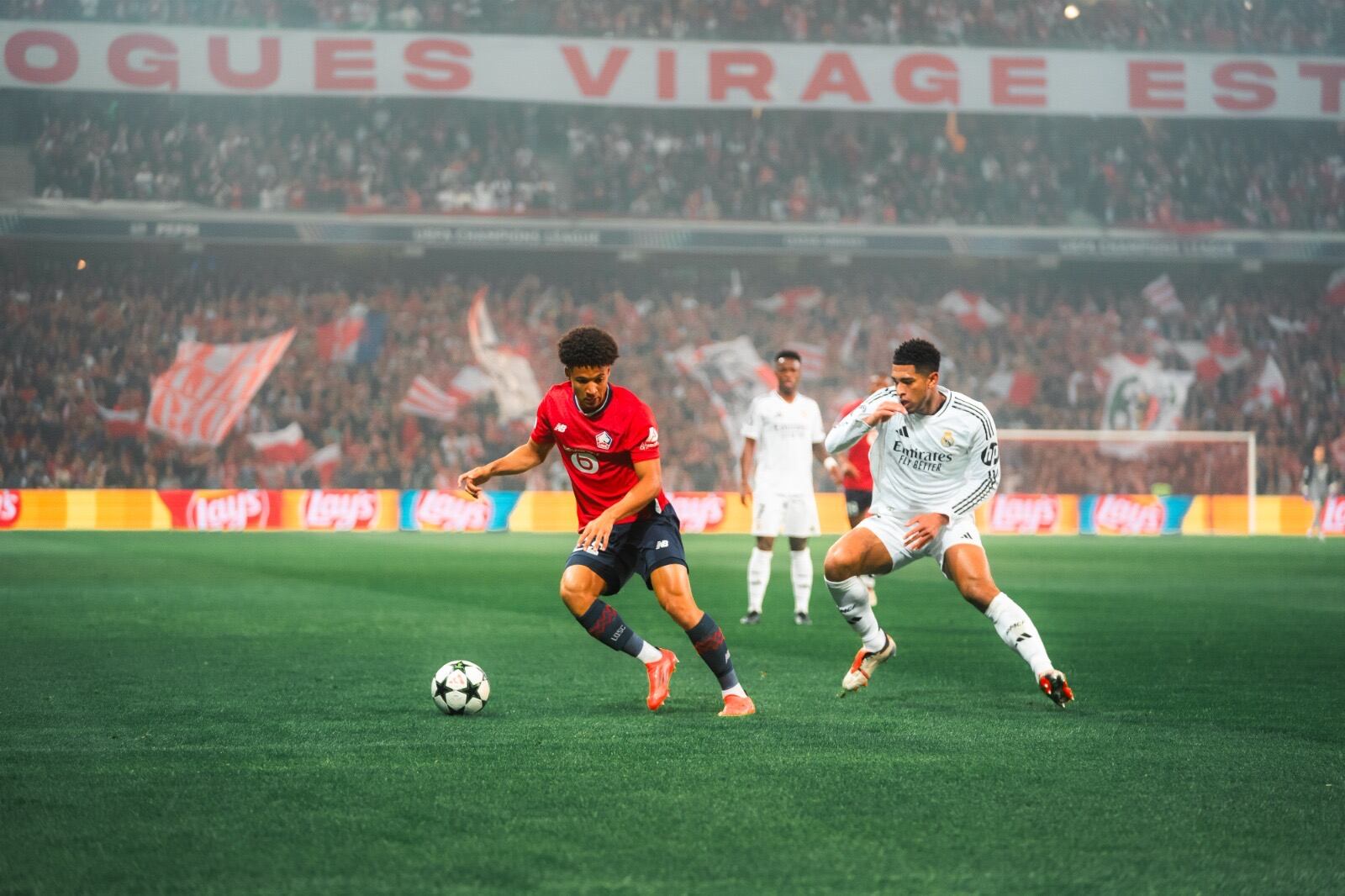 El madridista Jude Bellingham (de blanco) marca a Tiago Santos del Lille. Fotografía: Lille