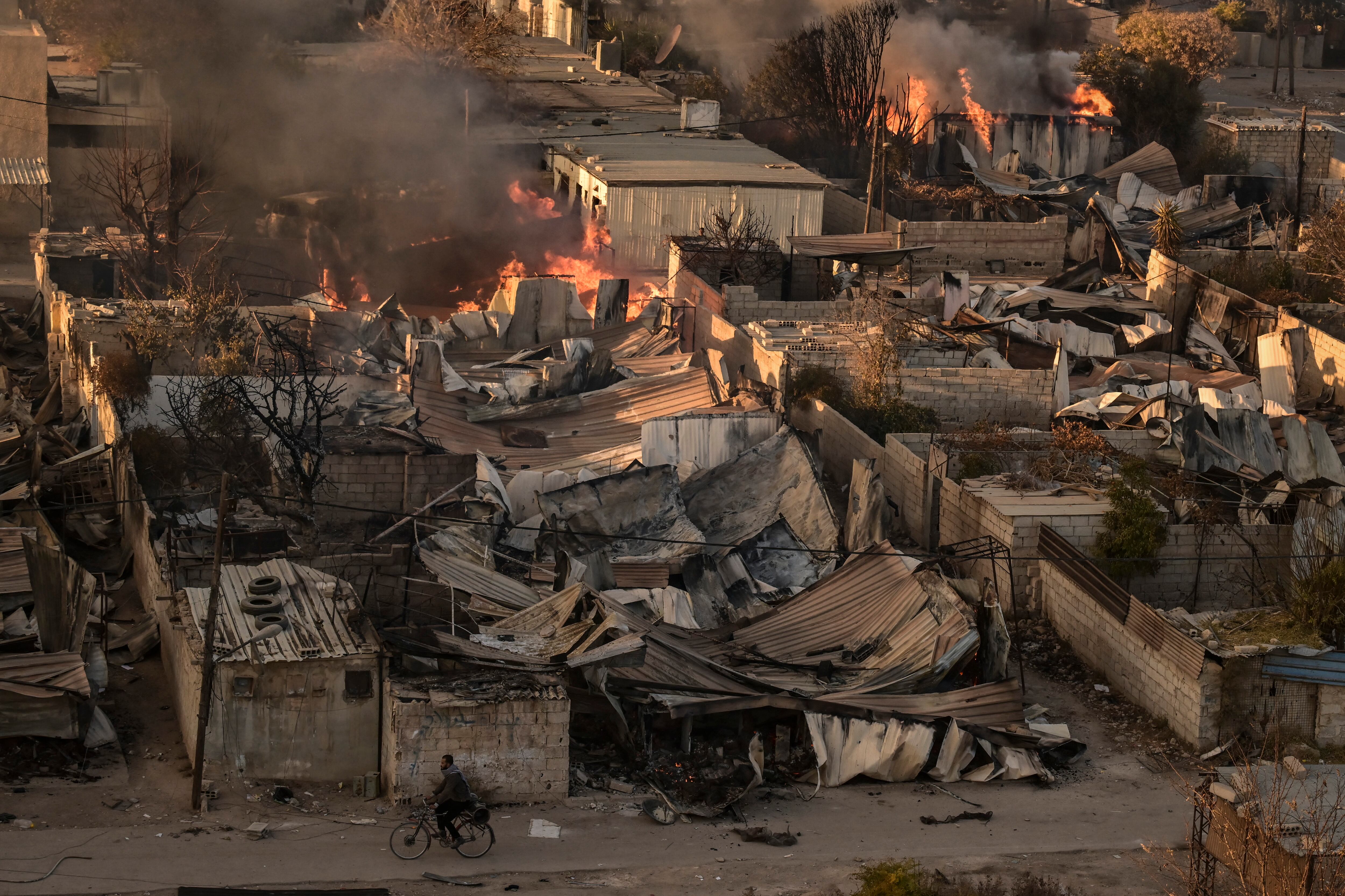 Un hombre monta una bicicleta en el saqueado complejo de viviendas militares de Najha, en el sureste de Damasco, tras la toma de la ciudad por rebeldes islamistas el 8 de diciembre de 2024.
