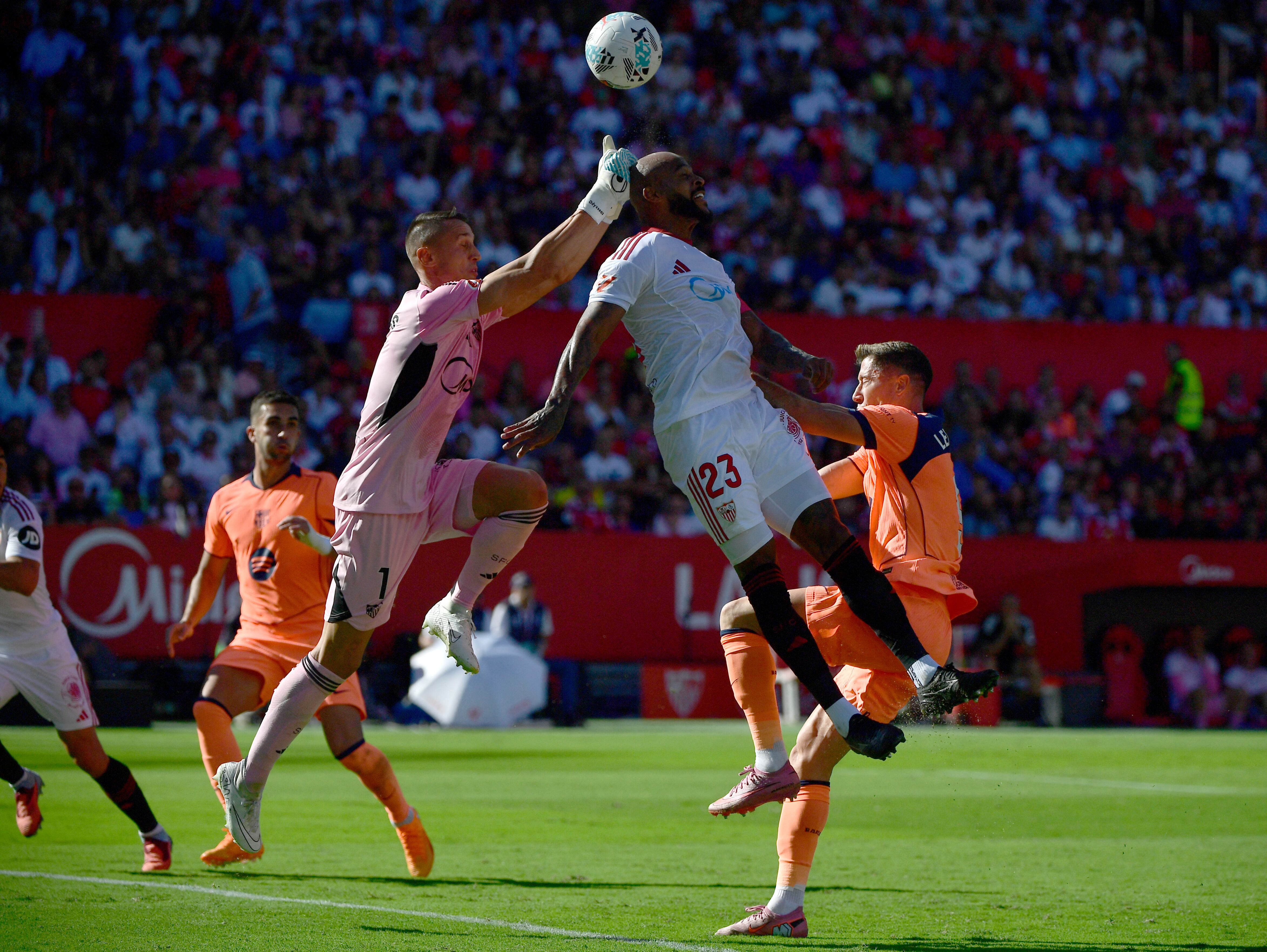 El arquero griego del Sevilla Odysseas Vlachodimos y el defensa brasileño Marcao Teixeira disputan el balón con el polaco del Barcelona Robert Lewandowski, durante el partido por la Liga Española disputado en el estadio Ramón Sánchez Pizjuán.