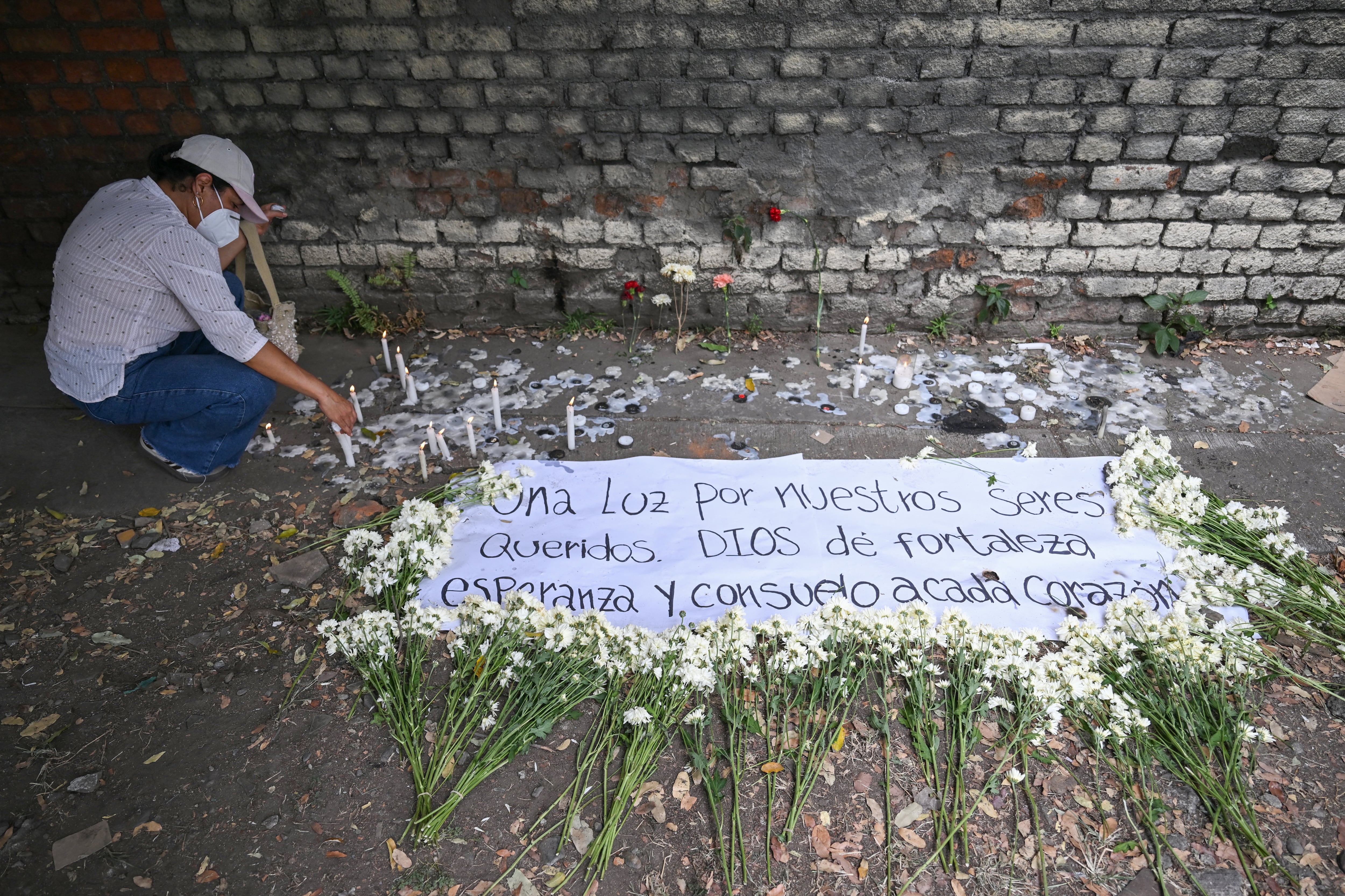 La voluntaria Gloria Alegrias enciende una vela en un memorial improvisado en homenaje a las víctimas del terremoto, frente a la morgue de Palmira, en el departamento de Valle del Cauca, Colombia, el 14 de agosto del 2026. Las posibilidades de encontrar sobrevivientes disminuyeron significativamente cuatro días después del sismo de magnitud 7,4, mientras continuaban las labores de rescate y cientos de personas permanecían desaparecidas.