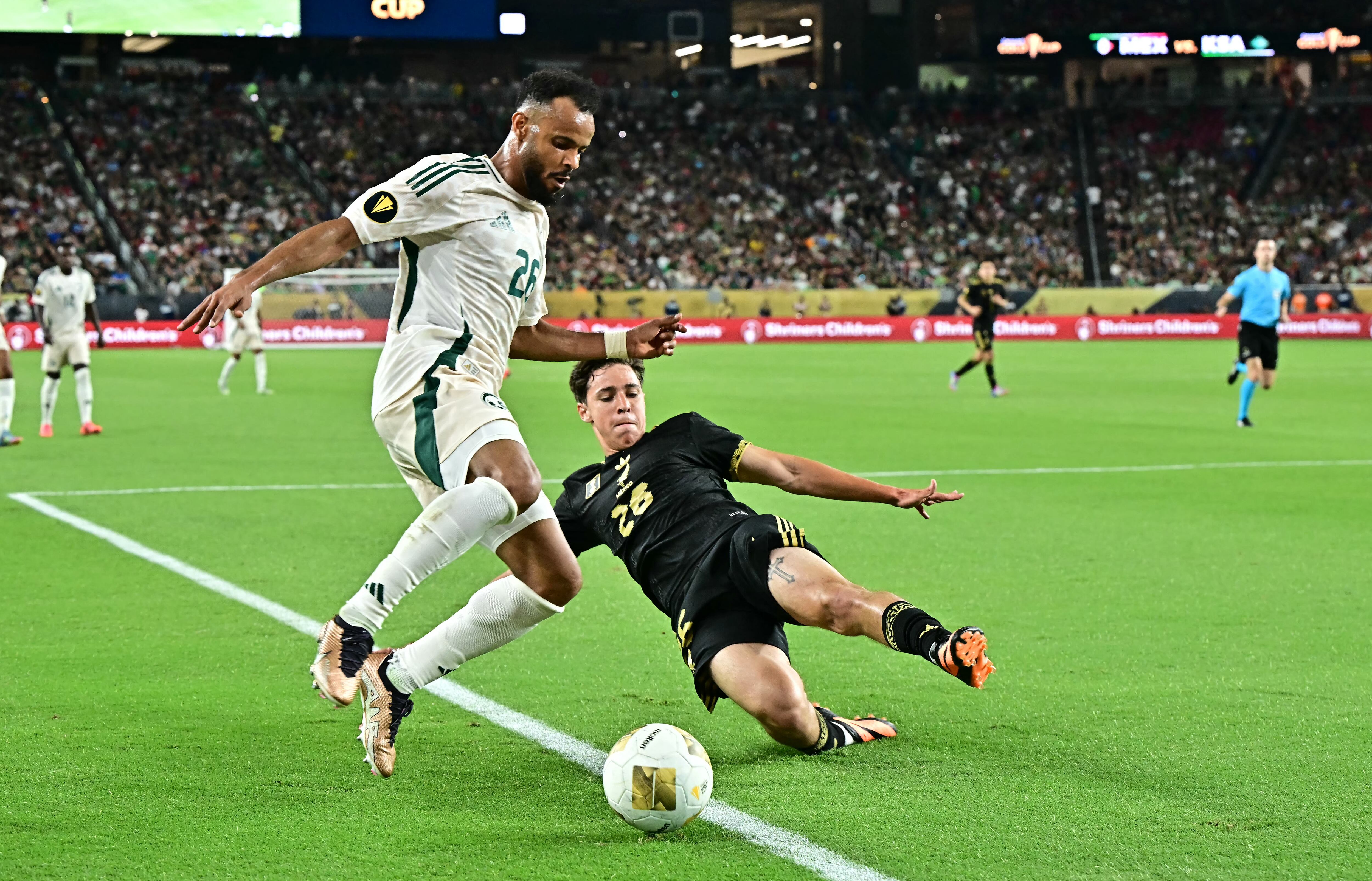 El defensa n.° 26 de Arabia Saudita, Ali Majrashi (izq.), y el defensa n.° 26 de México, Bryan González, disputan el balón durante el partido de cuartos de final