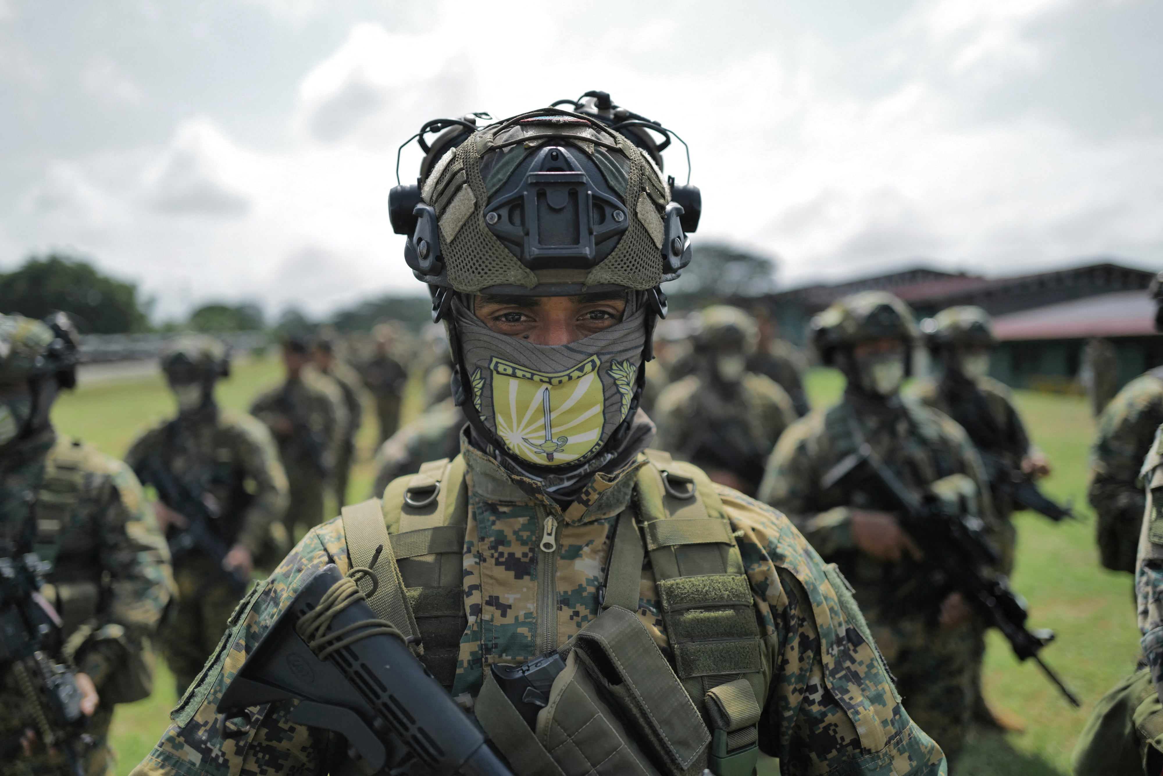 Un miembro del Servicio Nacional de Fronteras de Panamá (SENAFRONT) monta guardia durante una formación previa al inicio de la "Operación Escudo de Acero Fase 5" en la base militar Meteti, en la provincia de Darién, Panamá, el 9 de agosto de 2026, mientras un helicóptero sobrevuela la zona. Panamá reforzó su frontera con Colombia el 9 de agosto de 2026, tras los ataques ocurridos el primer día de la administración del presidente colombiano Abelardo de la Espriella, según anunció el gobierno panameño. El gobierno había descartado recientemente la posibilidad de incursiones en su territorio por parte de grupos irregulares colombianos.