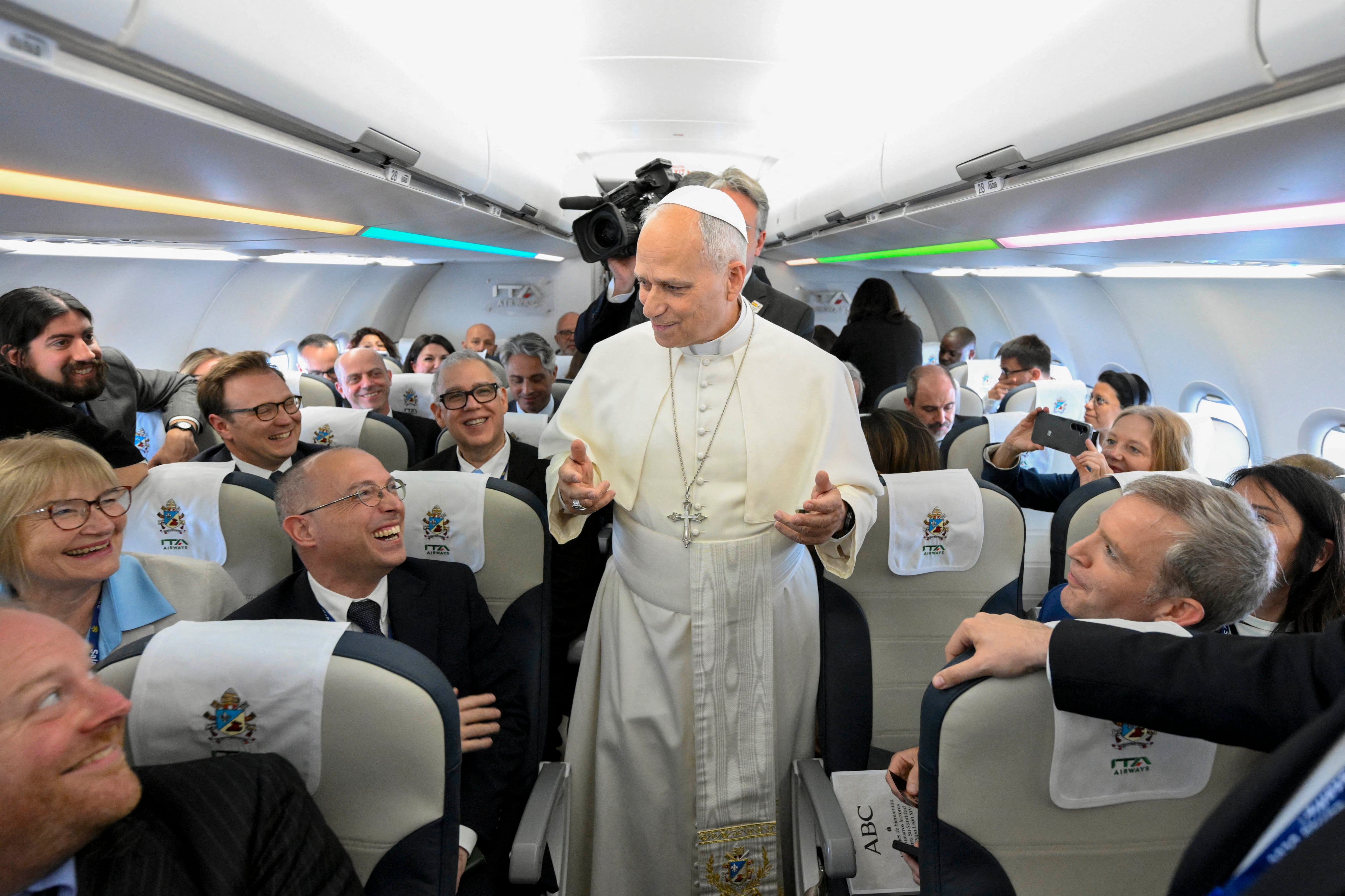 Esta fotografía distribuida por la oficina de prensa del Vaticano, tomada y publicada el 6 de junio de 2026 por Vatican Media, muestra al papa León XIV pronunciando un discurso ante los medios de comunicación a bordo del avión con destino a Madrid.
El papa León XIV realiza una visita a España del 6 al 12 de junio, con paradas en Madrid, Barcelona y las Islas Canarias, donde se reunirá con migrantes y con organizaciones dedicadas a ayudarlos. (Foto de Simone Risoluti / VATICAN MEDIA / AFP)