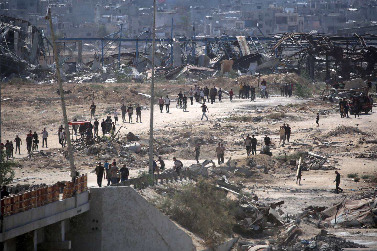 Personas se abren paso por el llamado "corredor Netzarim" cerca de Nuseirat, en el centro de la Franja de Gaza, el 10 de octubre de 2025, de regreso a la ciudad de Gaza. La agencia de defensa civil de Gaza informó el 10 de octubre que las fuerzas israelíes habían comenzado a retirarse de algunas zonas del territorio, en particular de la ciudad de Gaza y Khan Yunis.