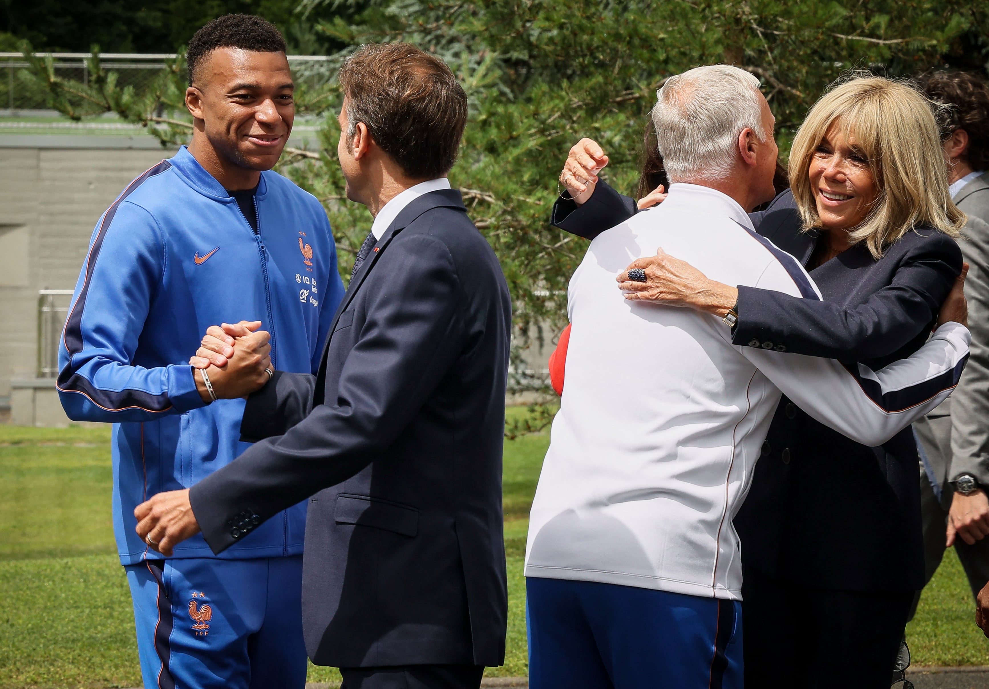 La estrella de la Selección de Francia, Kylian Mbappé, y el entrenador Didier Deschamps saludan al presidente Emmanuel Macron y su esposa Brigitte Macron, que acudieron al campo de entrenamiento en París.
