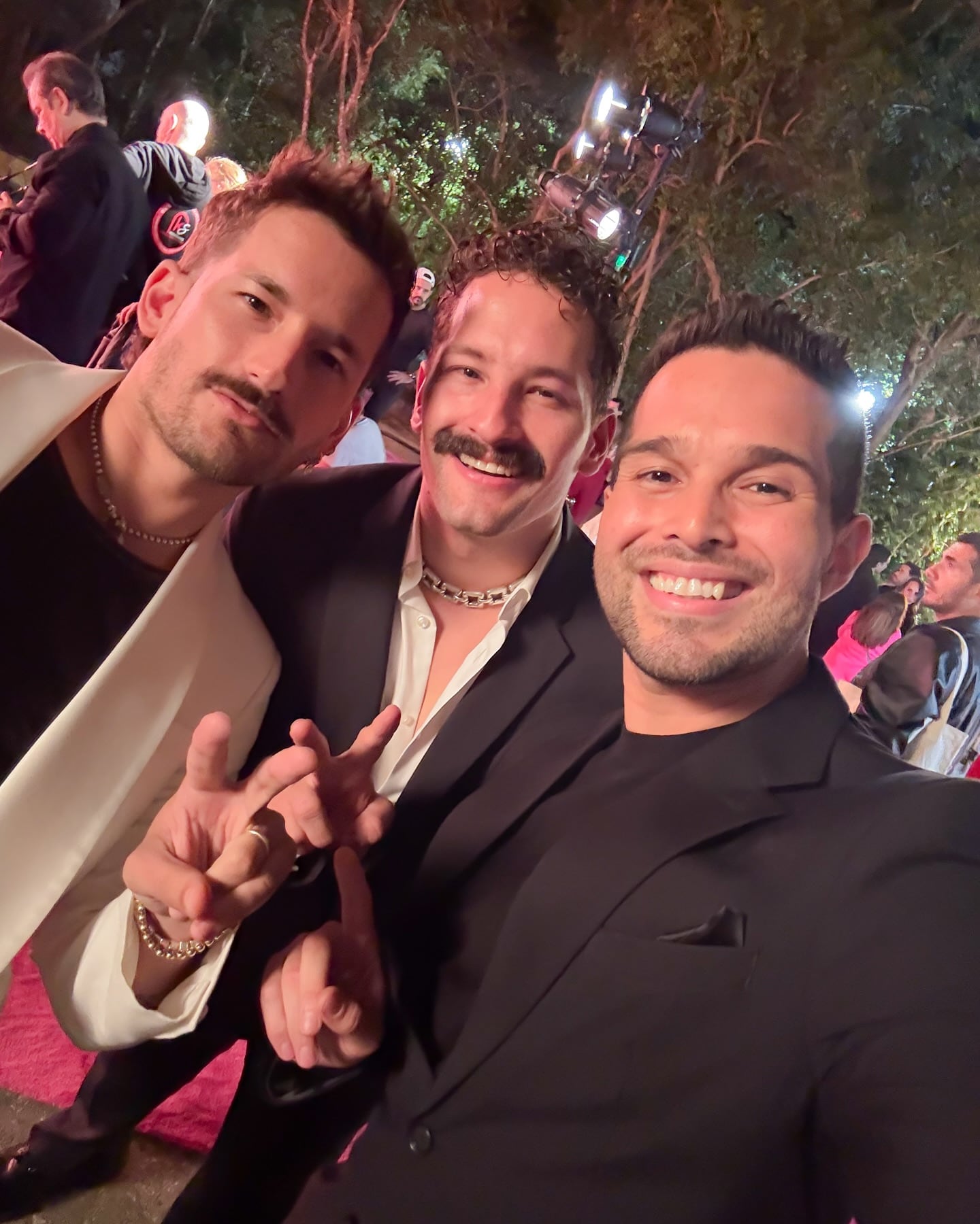 Eduardo Aguirre posando con los artistas Mau y Ricky.