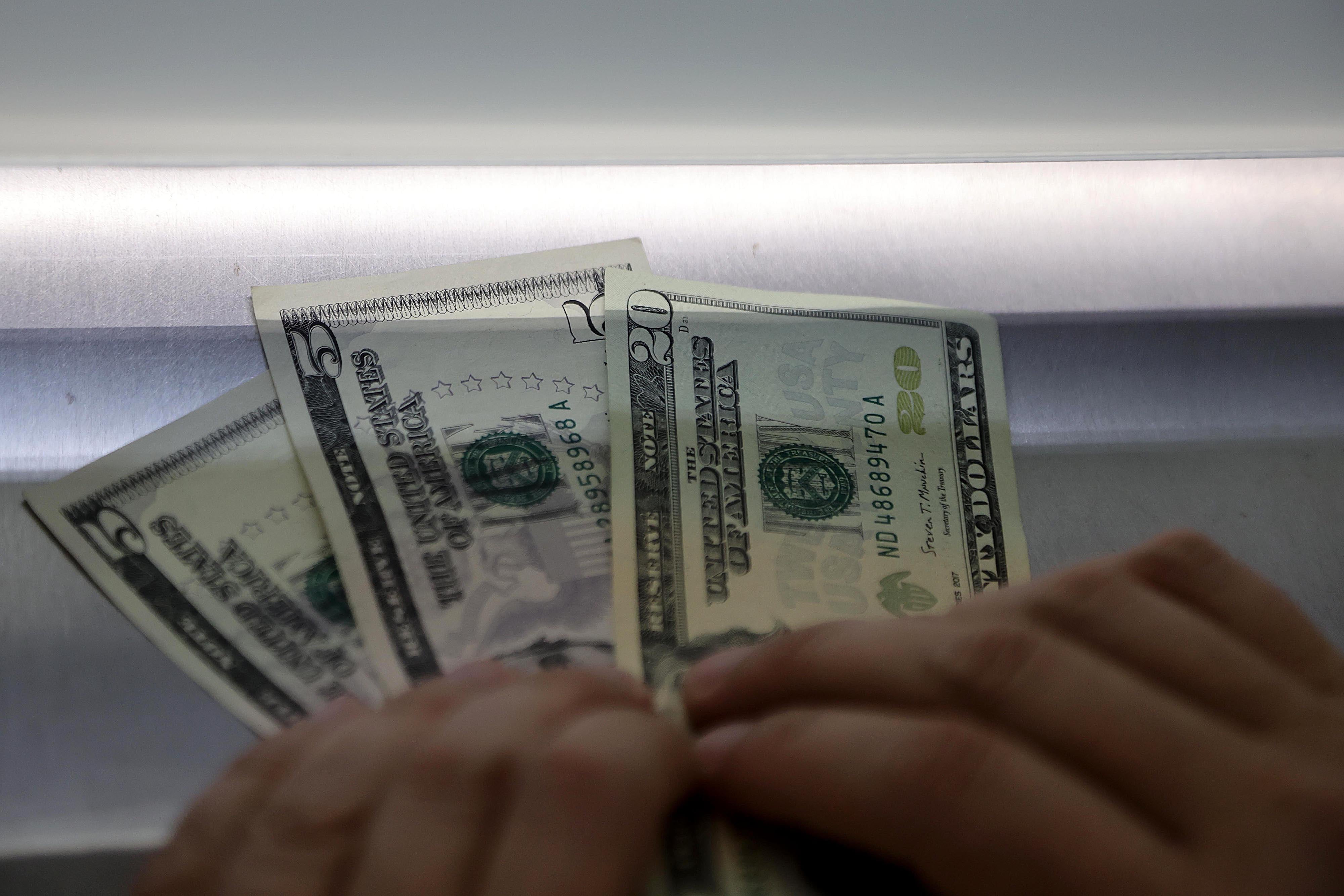 Primer plano de billetes de dólares estadounidenses en una transacción, en referencia al tipo de cambio en el Mercado de Monedas Extranjeras (Monex), que cerró en ¢504,44 el 17 de enero.