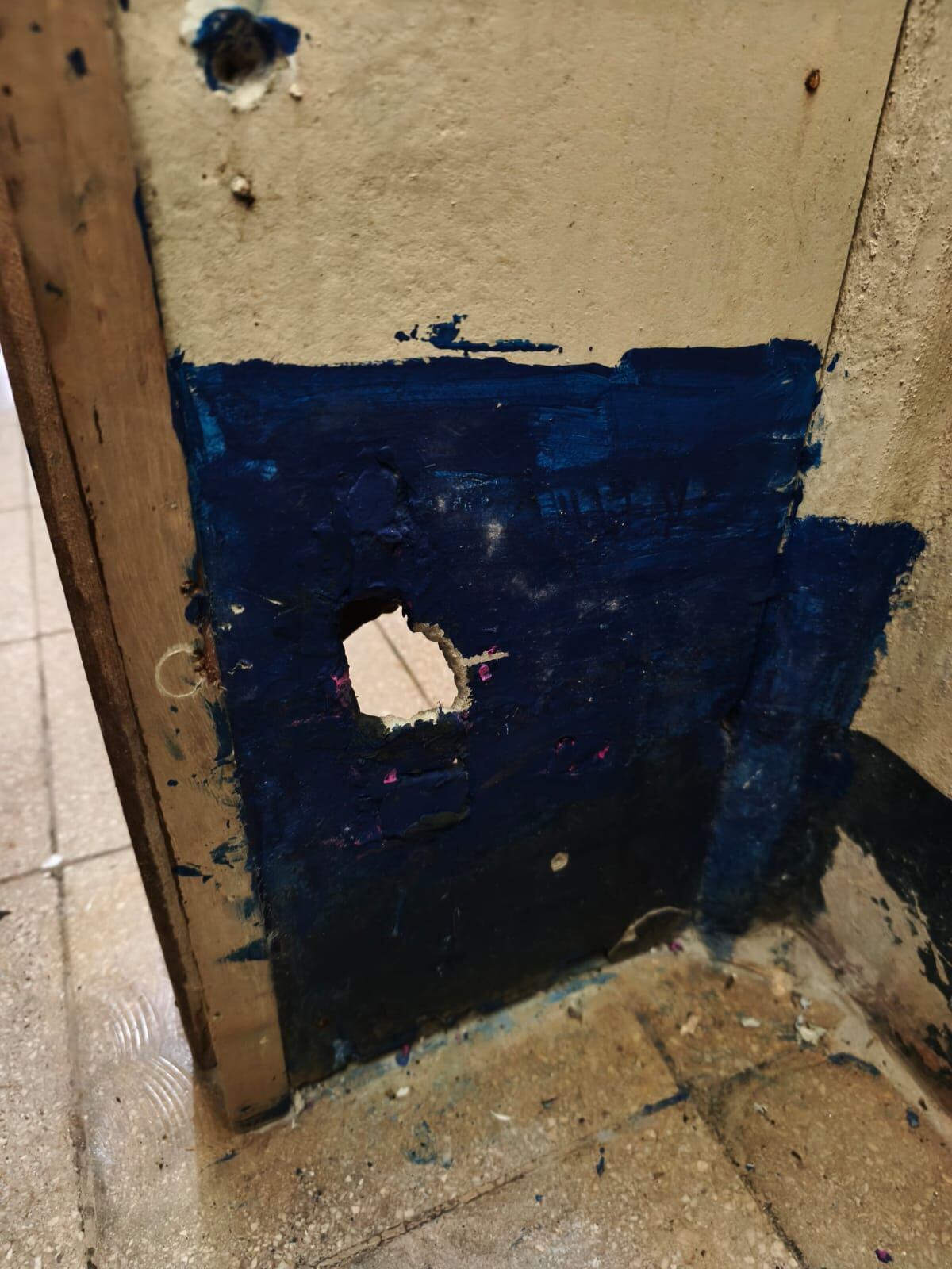En la imagen, la abertura en la pared del baño de niñas, con orientación directa hacia el inodoro, diseñada presuntamente para la grabación de personas menores de edad.