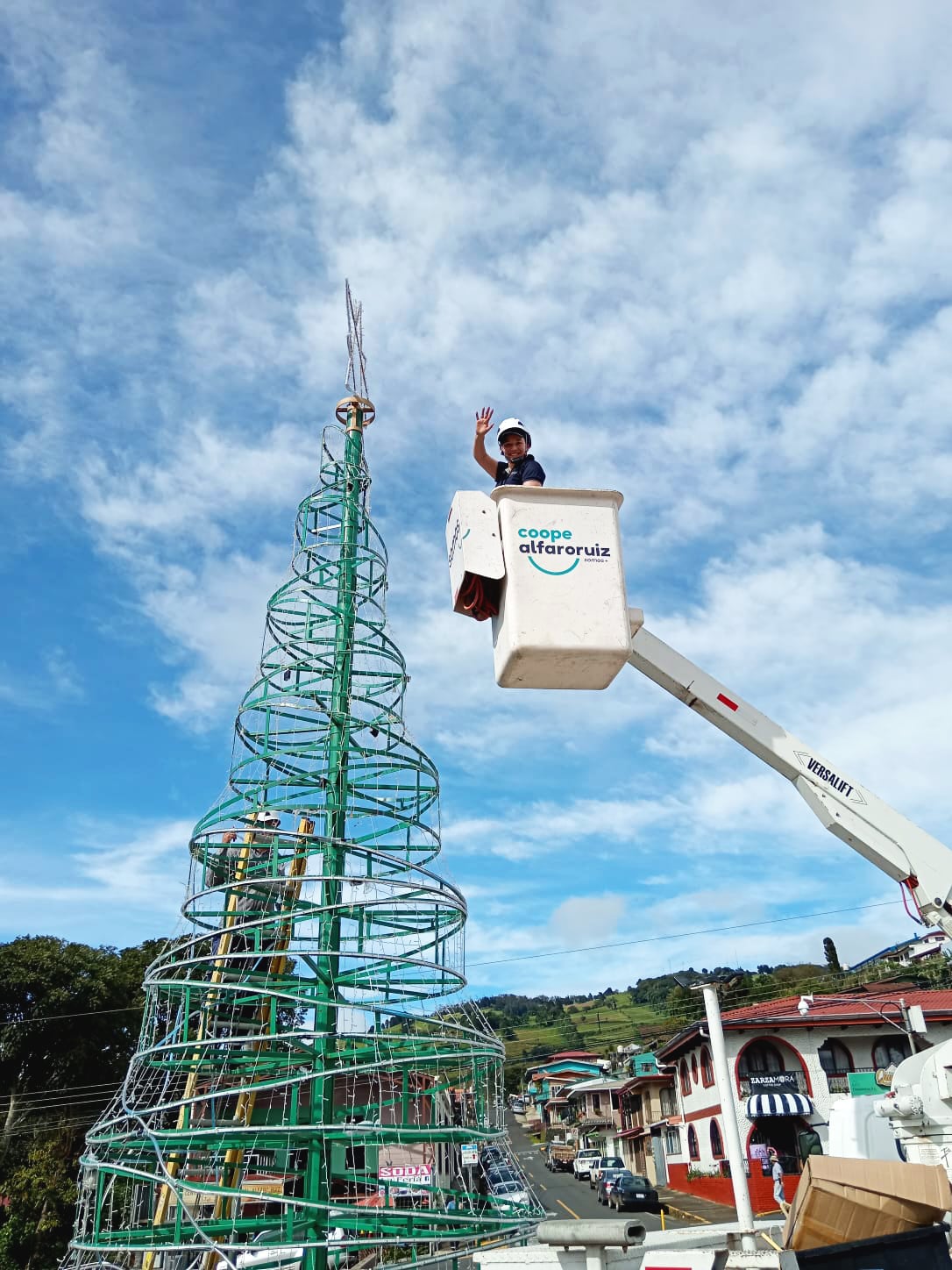 Una trabajadora instala luces navideñas en el icónico parque de Zarcero. Este domingo, el parque se iluminará para dar inicio a la temporada navideña, atrayendo a residentes y visitantes a esta tradicional celebración costarricense. Fotografía: Coopealfaroruiz R.L.