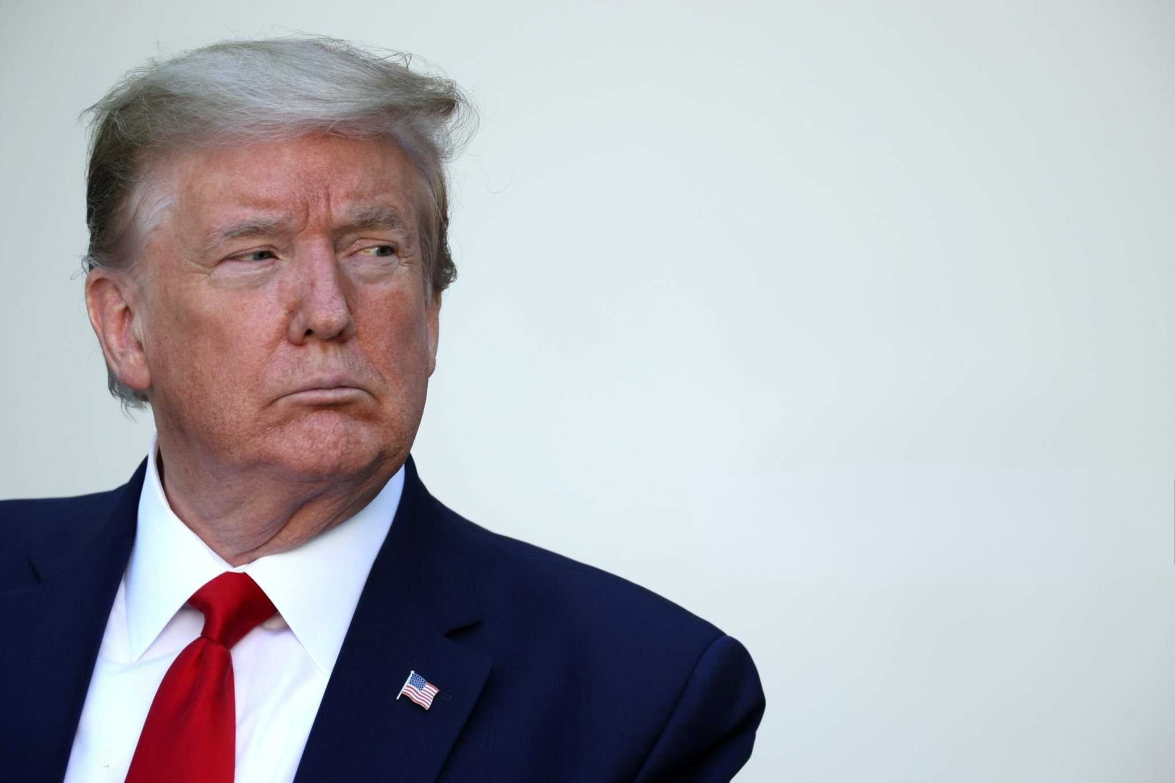 Donald Trump, expresidente de Estados Unidos, con traje oscuro y corbata roja, observa hacia un costado. Su administración implementó aranceles comerciales que impactaron a socios como Japón.