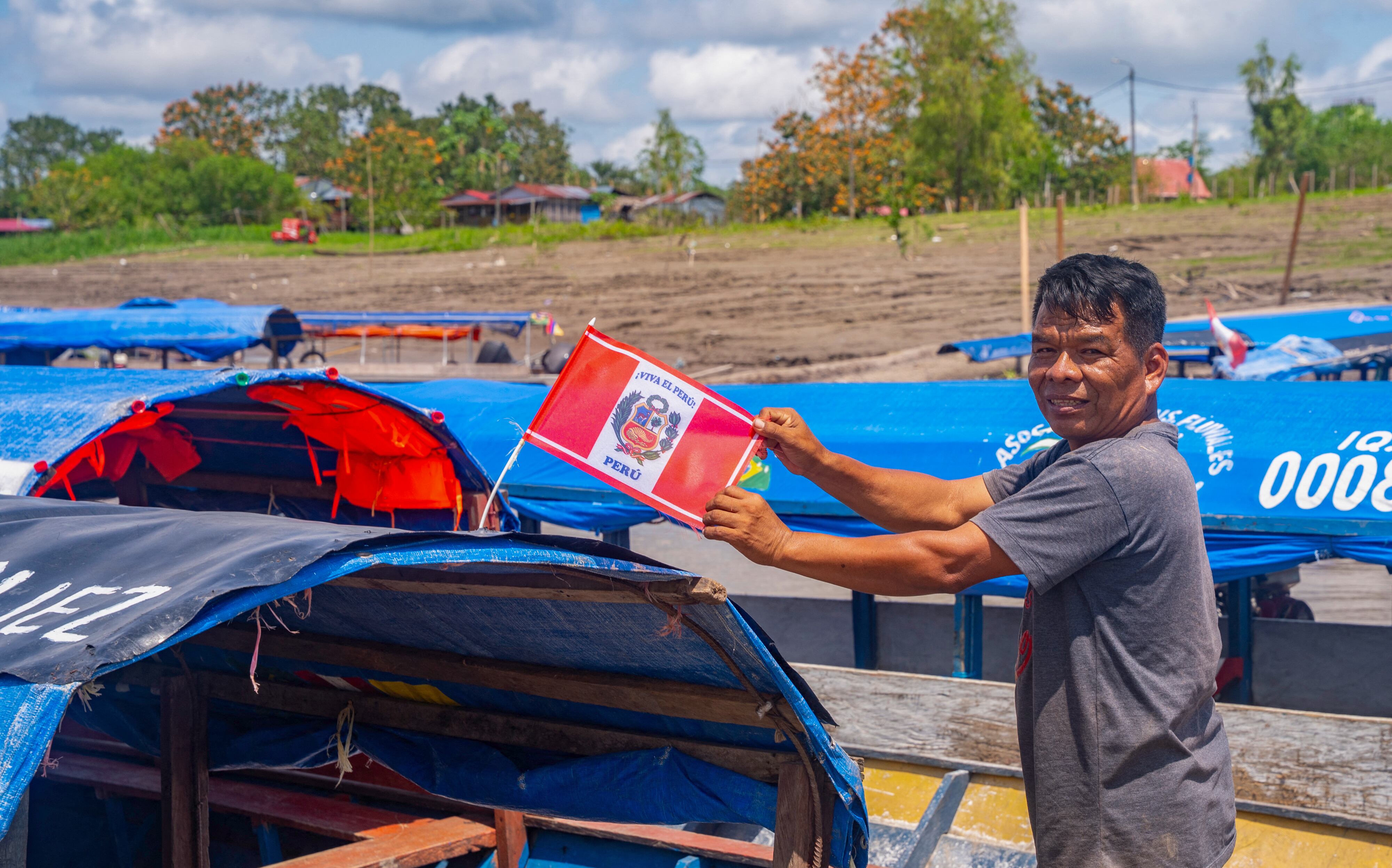 A boatman waits for passengers holding a Peruvian flag in Santa Rosa Island, Peru on August 5, 2025. Peru on August 5, 2025, expressed its "strong protest" over statements by Colombia's President Gustavo Petro questioning its sovereignty over an Amazonian island on the shared border between the two countries, according to a statement from the Foreign Ministry. (Photo by Santiago RUIZ / AFP)