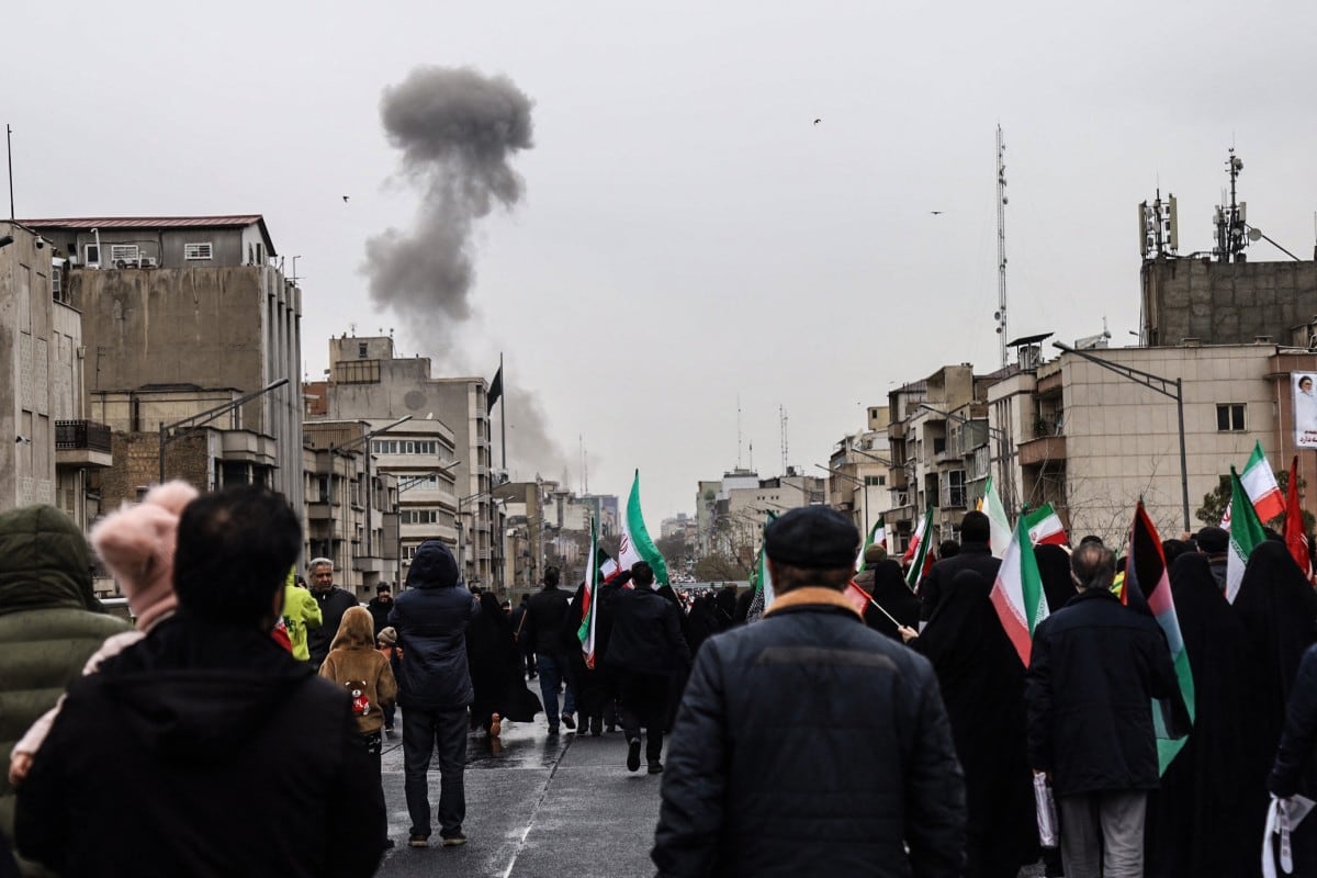 Multitud observa resultado de un bombardeo en Teherán.
