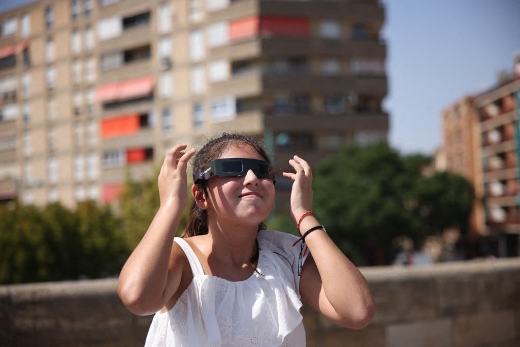 Una persona usa gafas especiales mientras se prepara para observar el eclipse solar total desde el puente de Piedra, en Zaragoza, España, el 12 de agosto de 2026. Zaragoza experimentará una cobertura total del 100 % del Sol, con una duración aproximada de 1 minuto y 27 segundos.