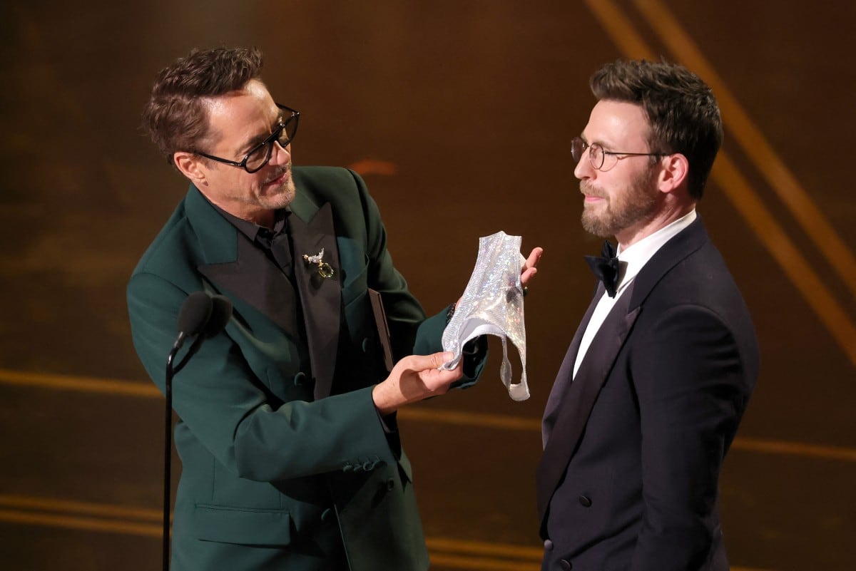 HOLLYWOOD, CALIFORNIA - MARCH 15: (L-R) Robert Downey Jr. and Chris Evans speak onstage during the 98th Oscars at Dolby Theatre on March 15, 2026 in Hollywood, California. Kevin Winter/Getty Images/AFP (Photo by KEVIN WINTER / GETTY IMAGES NORTH AMERICA / Getty Images via AFP)