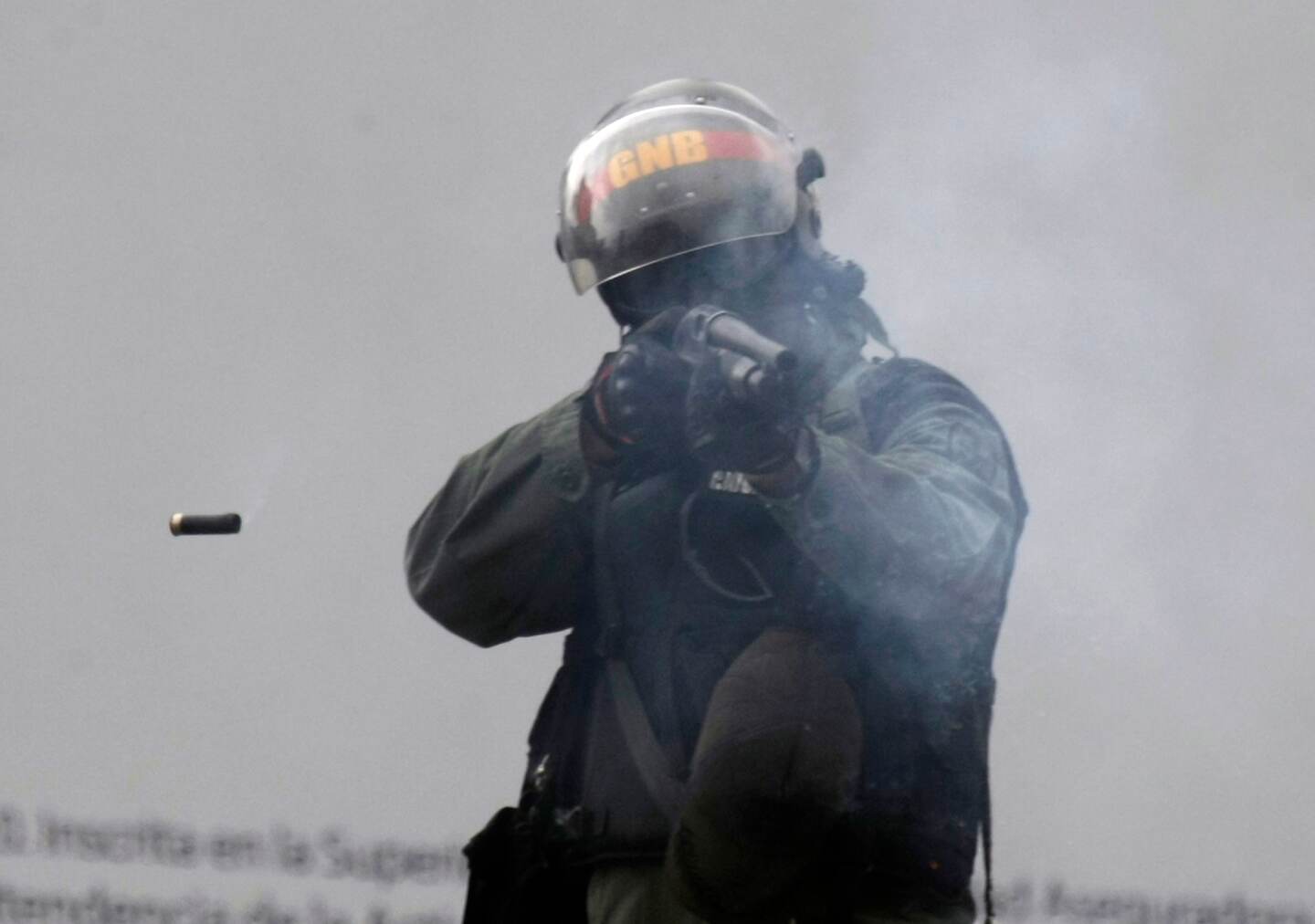Un oficial dispara su escopeta (con perdigones) contra manifestantes durante los enfrentamientos entre autoridades y manifestantes antigubernamentales en Caracas, Venezuela, el miércoles 7 de junio.