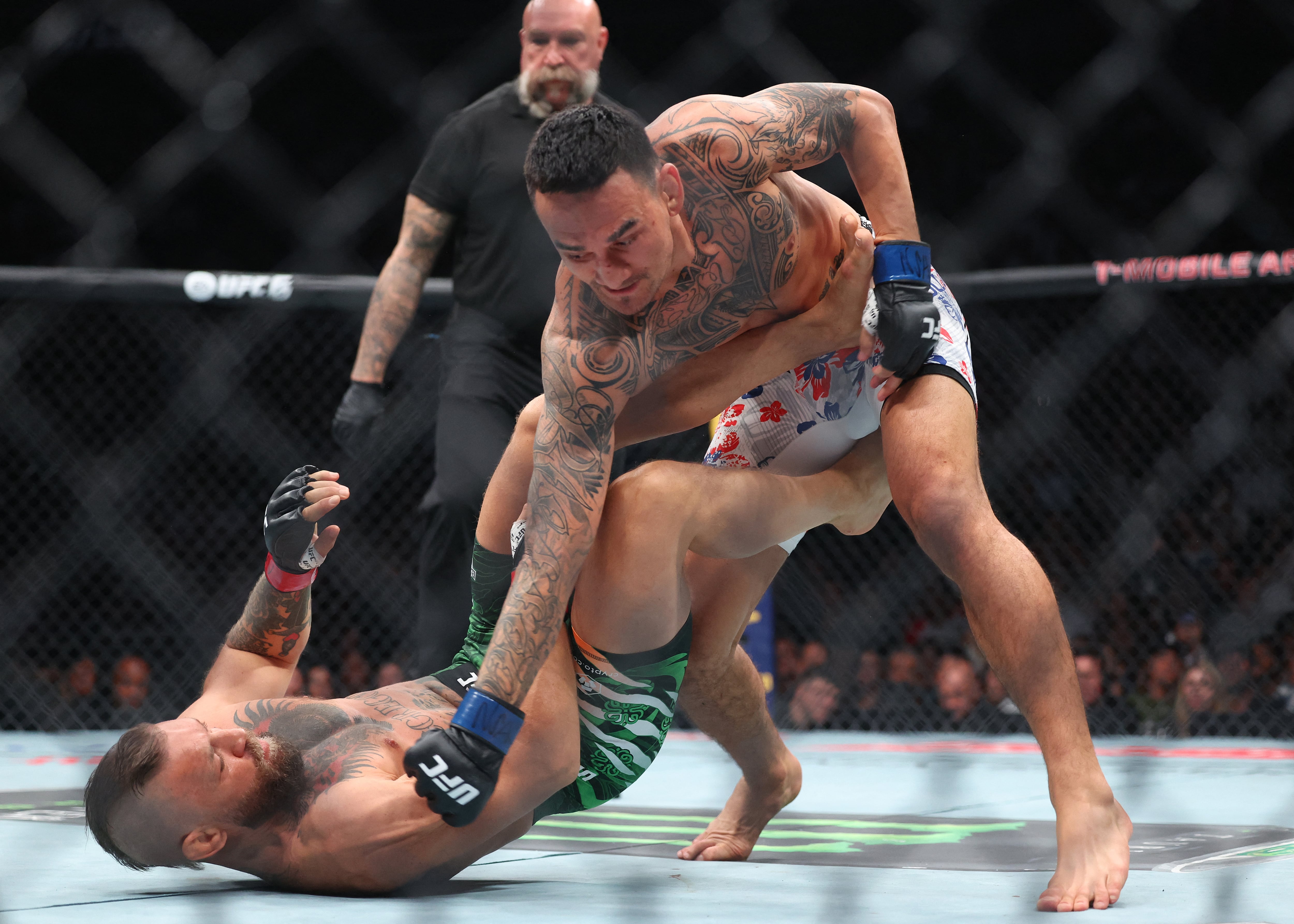 El estadounidense Max Holloway le lanza un golpe a Conor McGregor, de Irlanda (en el suelo), durante la velada UFC 329 que se realizó en la T-Mobile Arena de Las Vegas este 11 de julio.