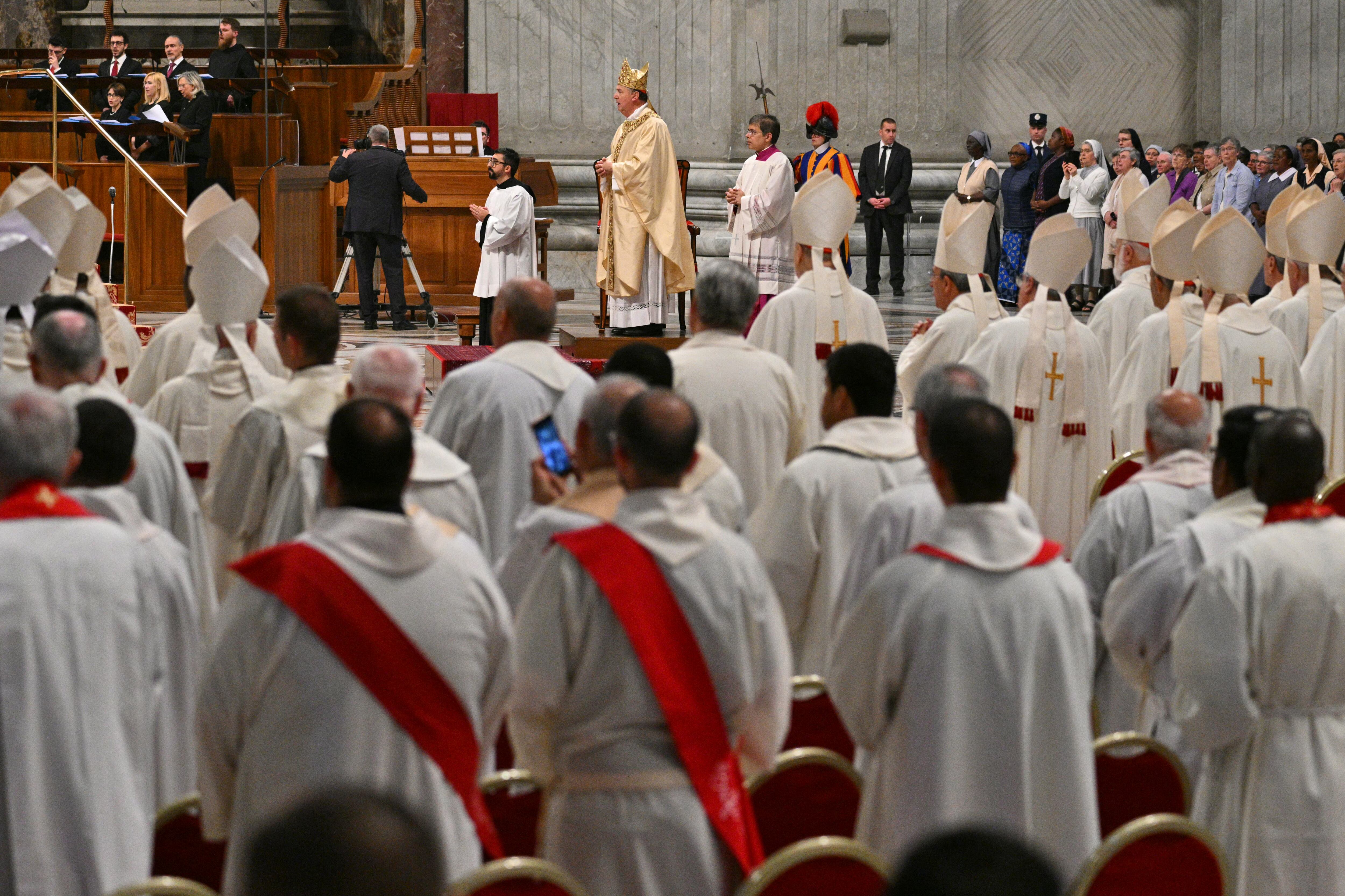 Imagen de la misa con los cardenales de este sábado. La mayoría se ve de espaldas, y se ve, de perfil, el desfile del cardenal que preside la misa.