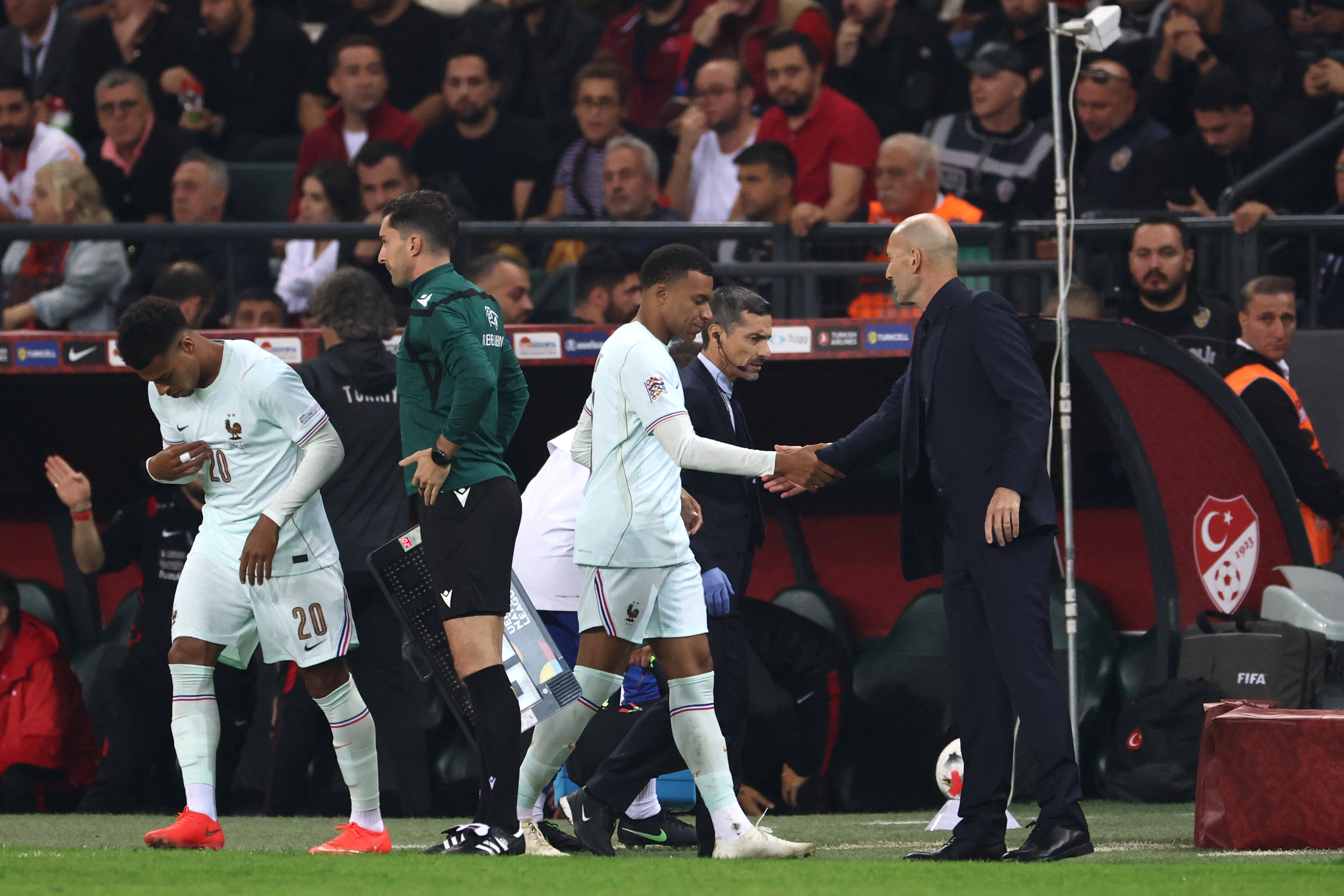El entrenador Zinedine Zidane saluda a Kylian Mbappé, sustituido por lesión en el partido de Francia ante Turquía por la Nations League de Europa.